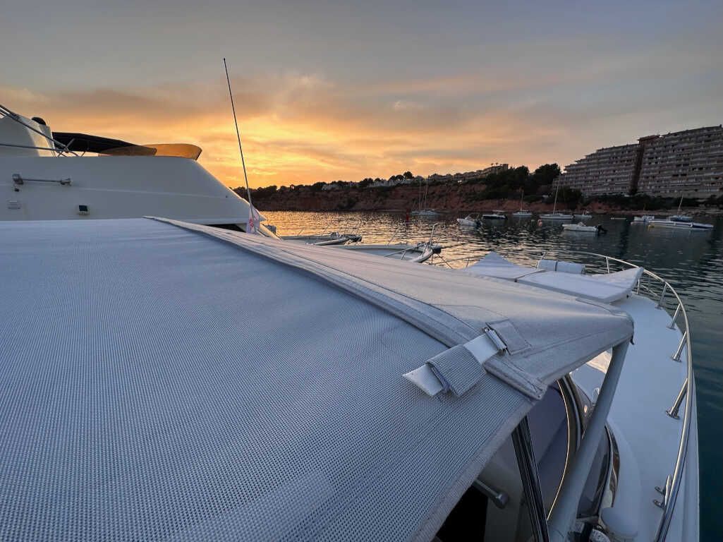 Un barco está en el agua con una puesta de sol de fondo.