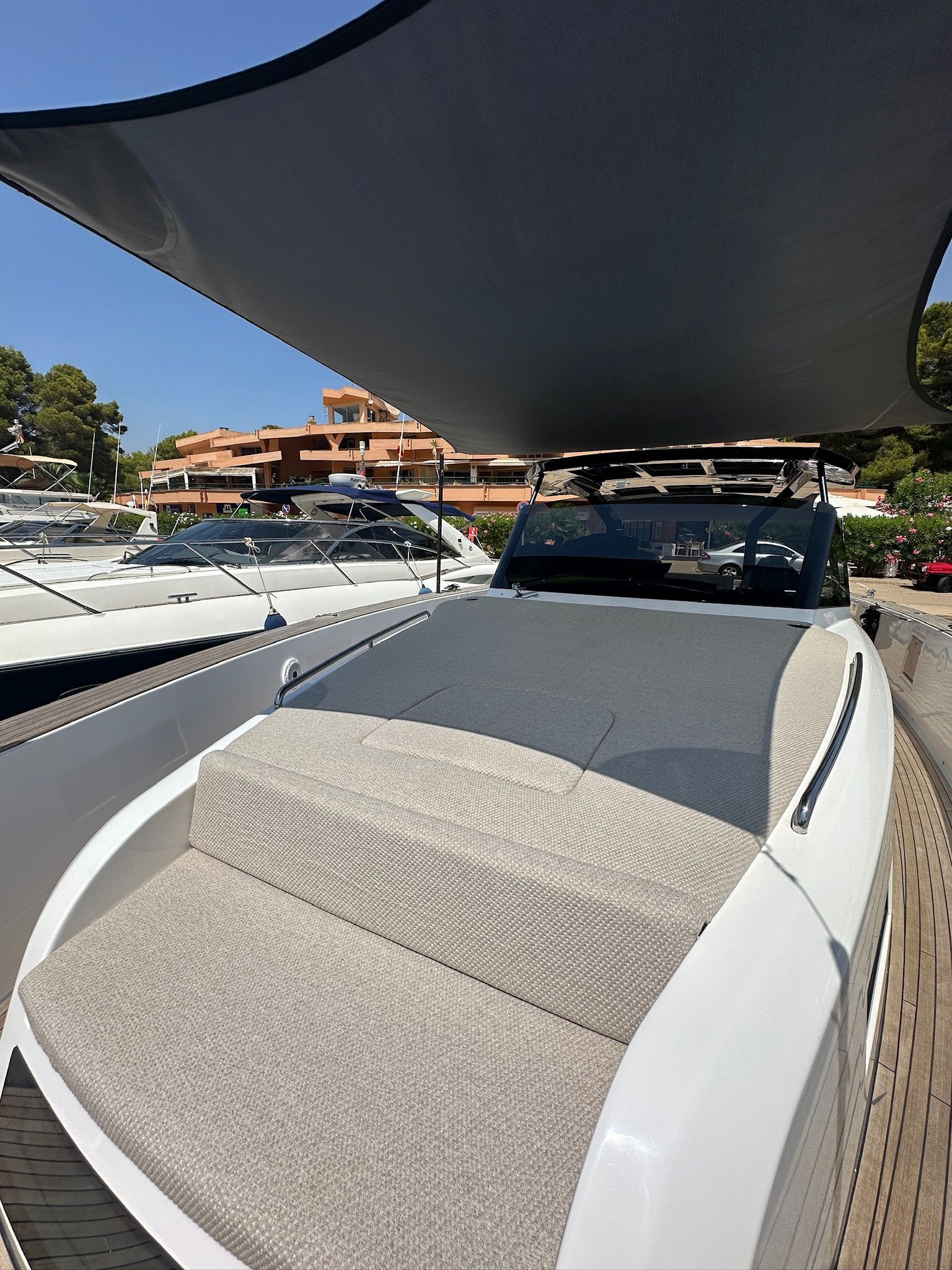 El interior de un barco con asientos blancos y un volante.