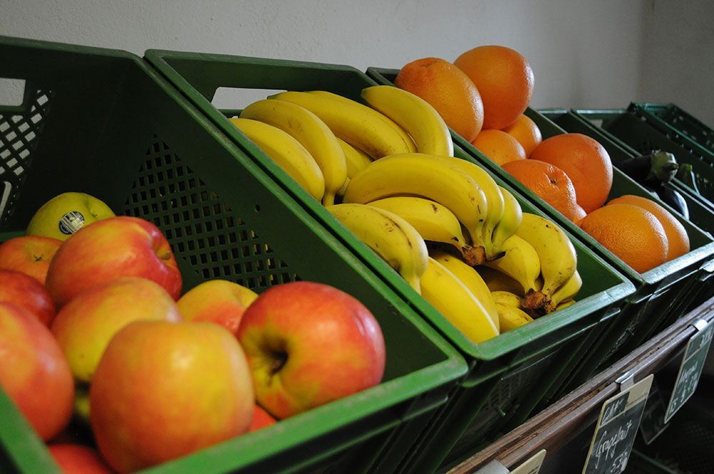 Eine Anzeige von Äpfeln, Bananen und Orangen auf einem Regal