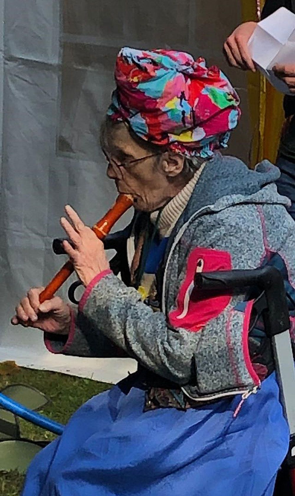 Eine Frau im Rollstuhl spielt Flöte.