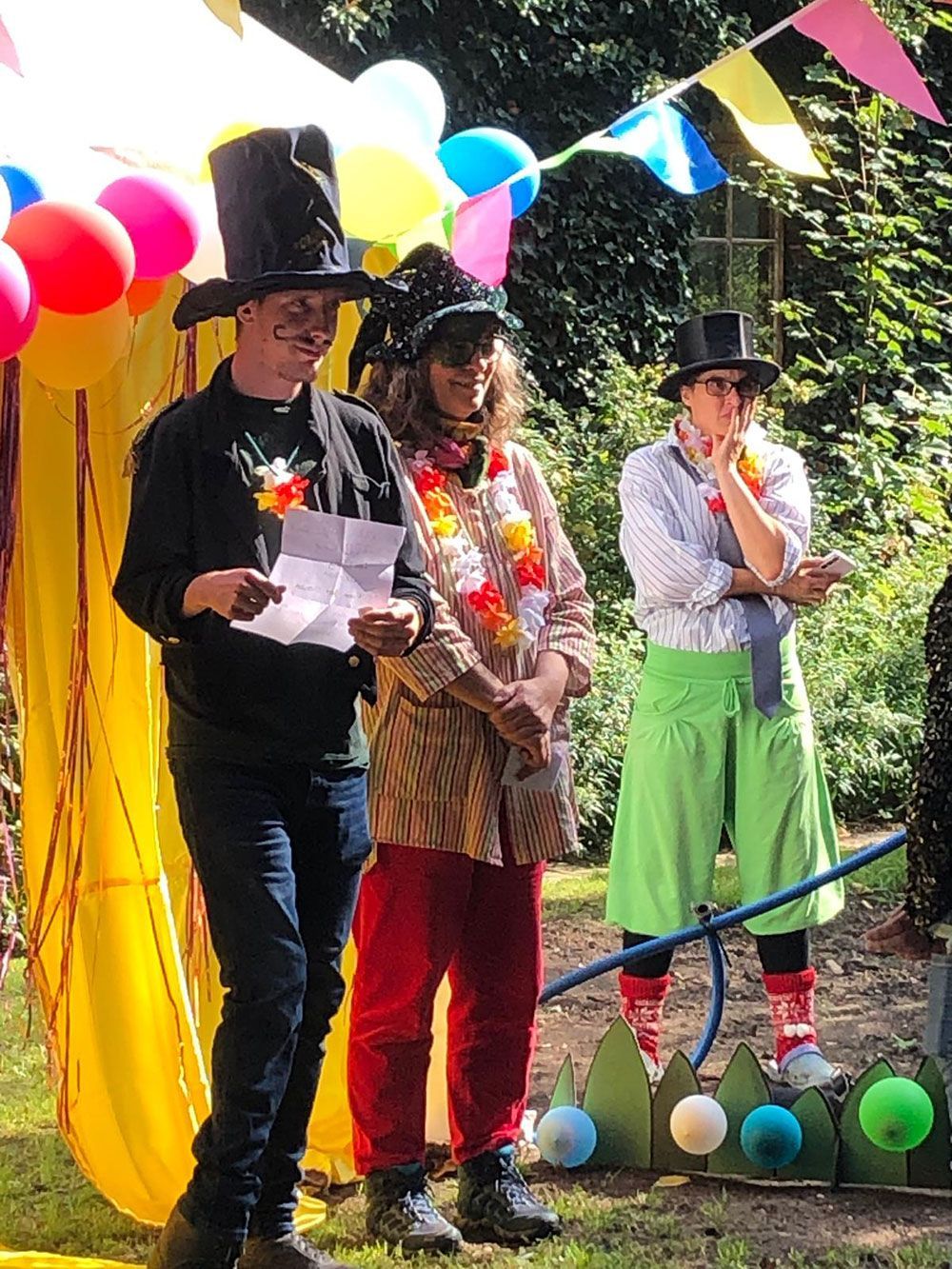 Eine Gruppe kostümierter Menschen steht vor Luftballons.