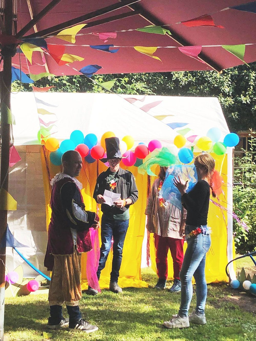 Eine Gruppe von Menschen steht vor einem Zelt mit Luftballons