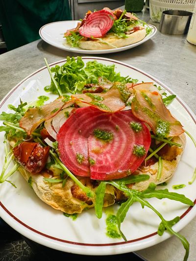 Deux assiettes de salade avec des tranches de thon rose sur une table, garnies de verdure et d'oignons croustillants.