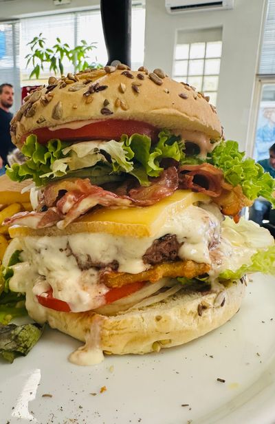 Un grand cheeseburger avec laitue, bacon, tomate et fromage fondu.