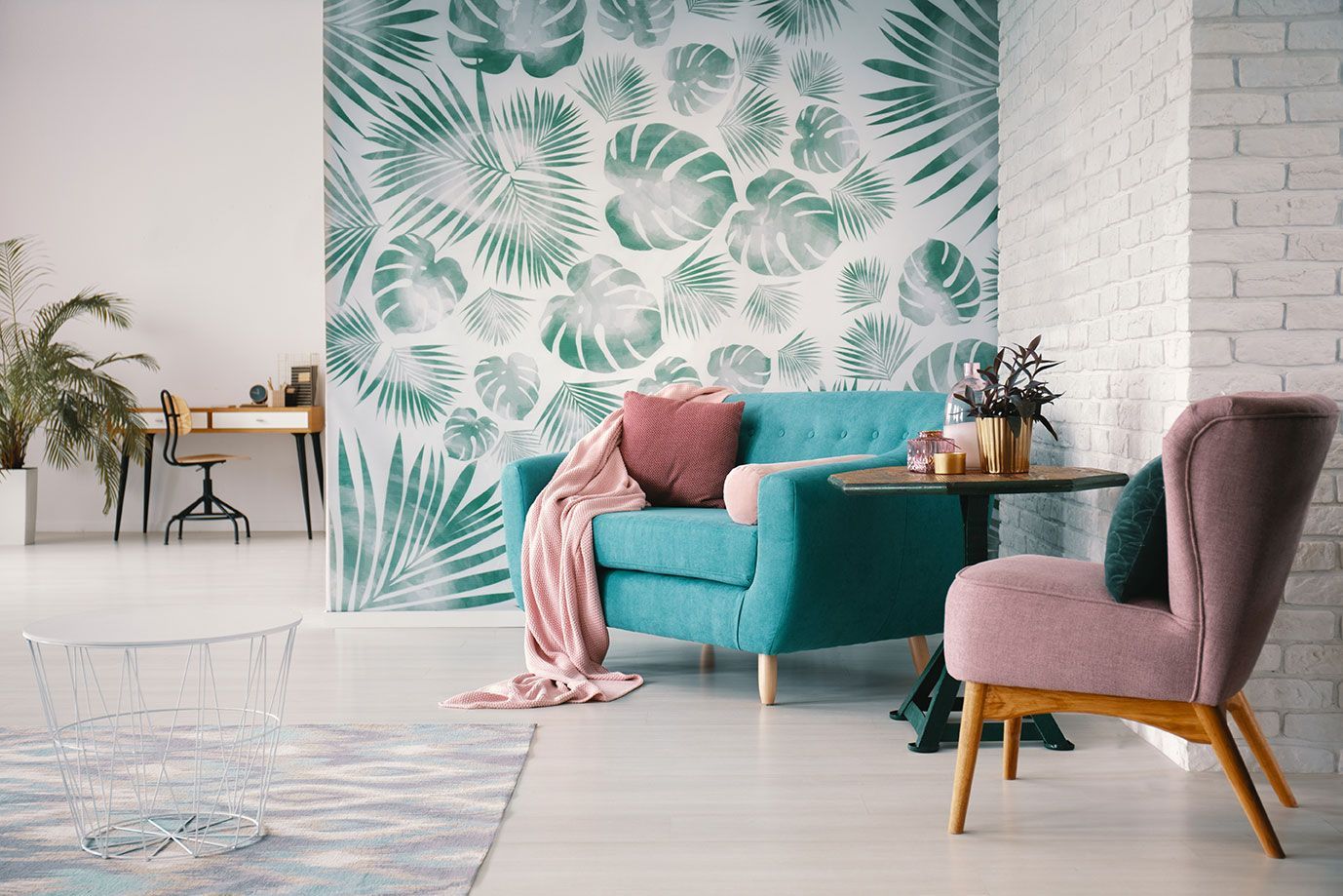 Chaise et canapé turquoise à l'intérieur d'un salon avec un mur en papier peint