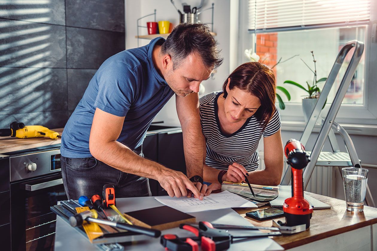 Un artisan et une femme regardent ensemble des plans
