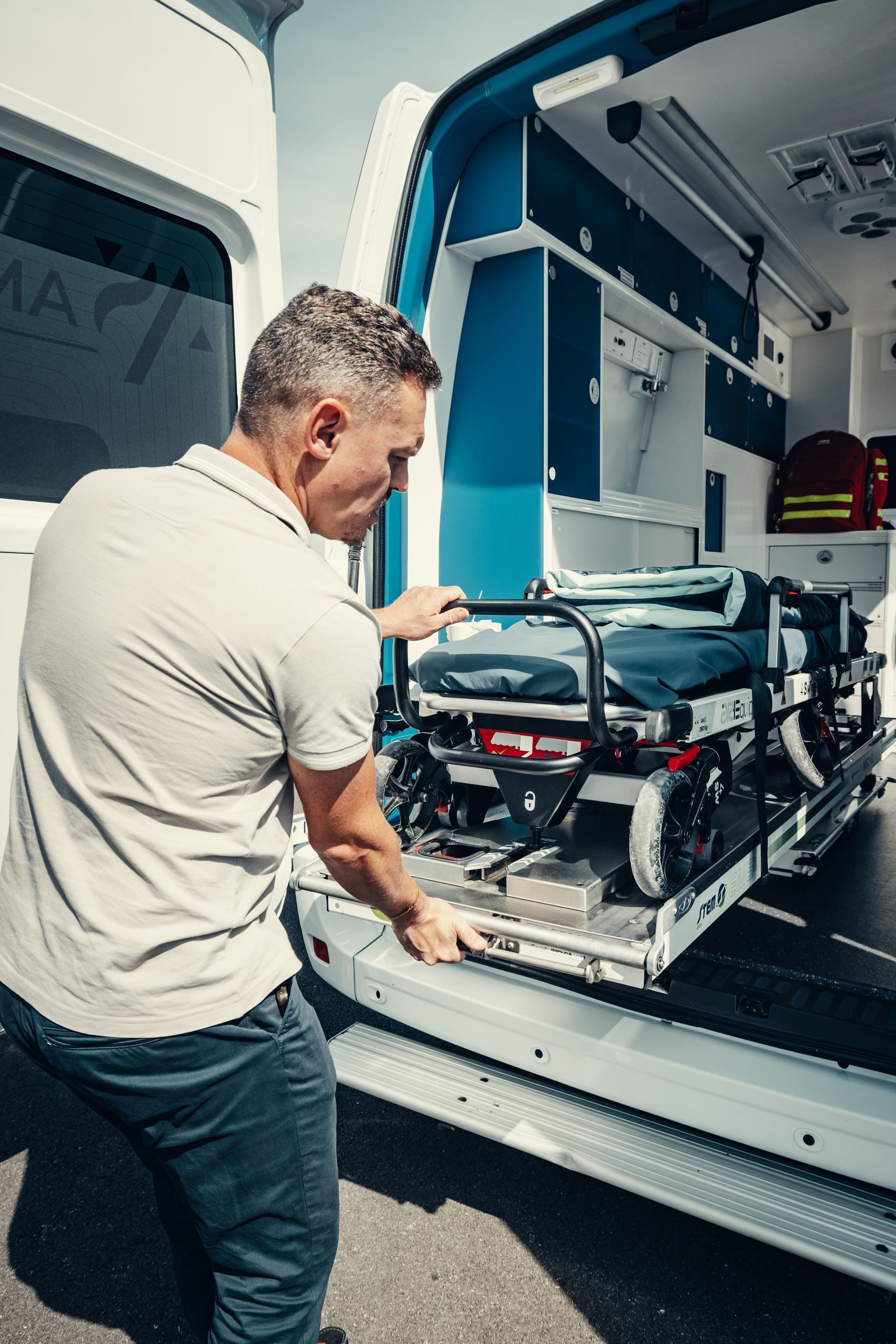 Une ambulance roule à vive allure dans une rue de la ville, gyrophares allumés.