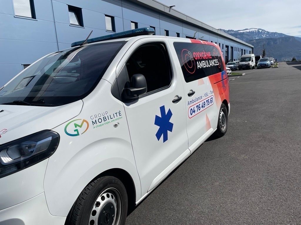 Deux ambulances blanches garées côte à côte, chacune portant l'inscription AMBULANCE et le symbole bleu de l'étoile de vie.