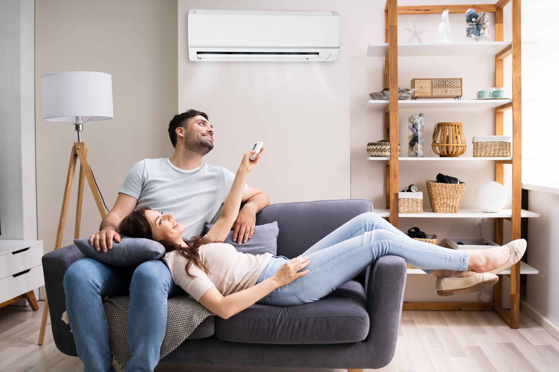 Une couple dans leur canapé profite de la climatisation.