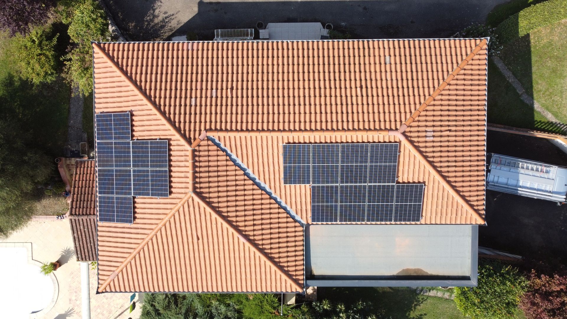 Panneaux photovoltaïques sur un toit de maison vu de haut.
