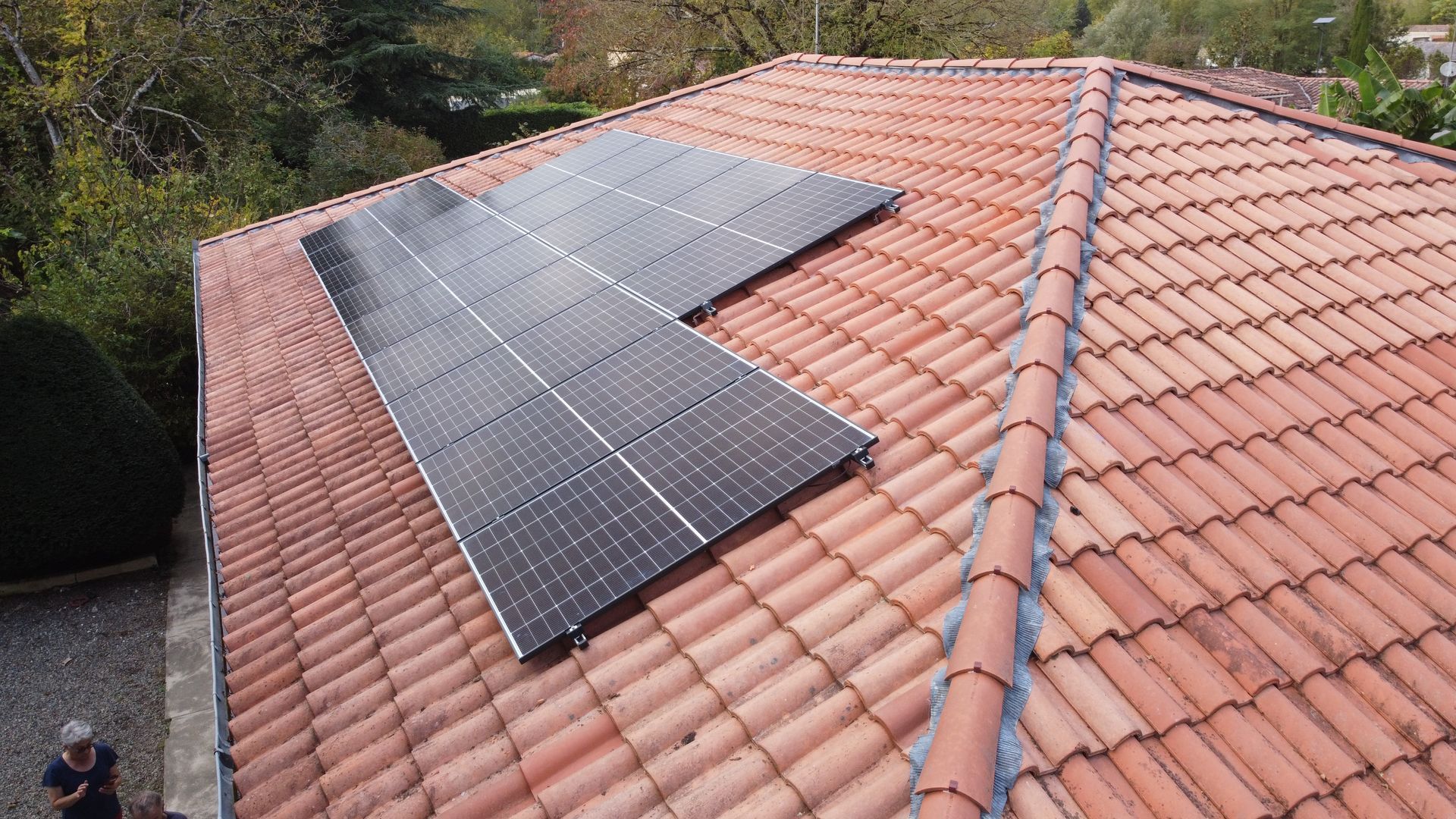 Plusieurs panneaux photovoltaïques sur un toit en tuiles.