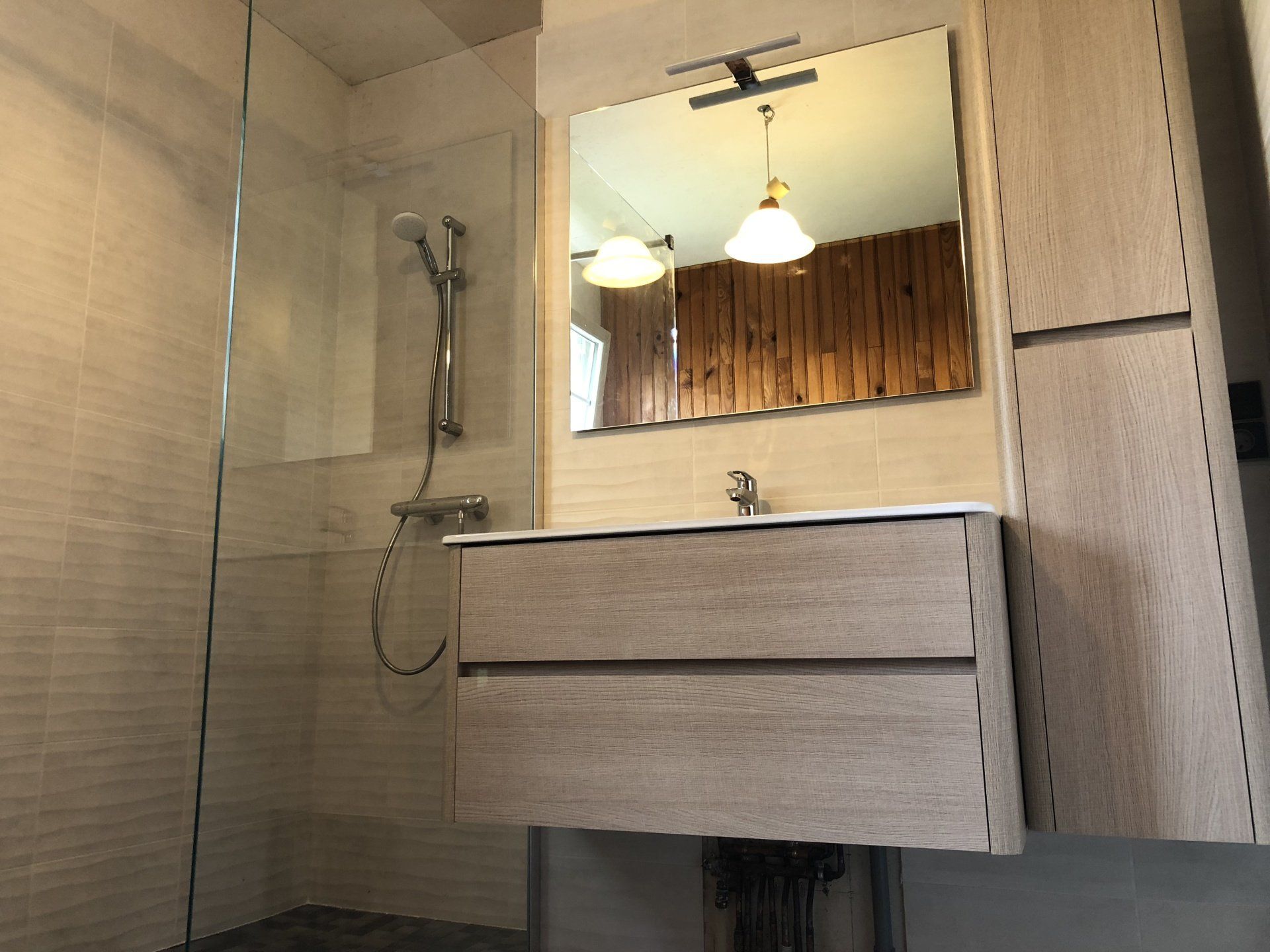 Un miroir au-dessus d'un meuble de salle de bains.