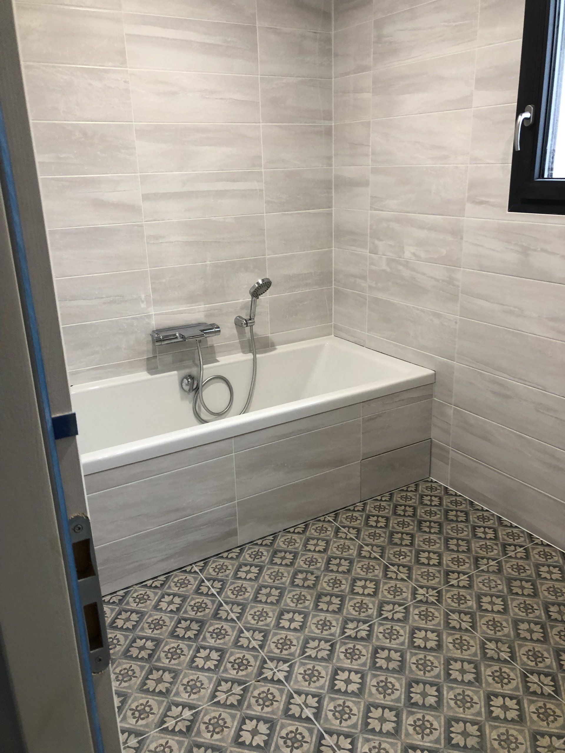 Salle de bains avec une baignoire et une robinetterie centrale.