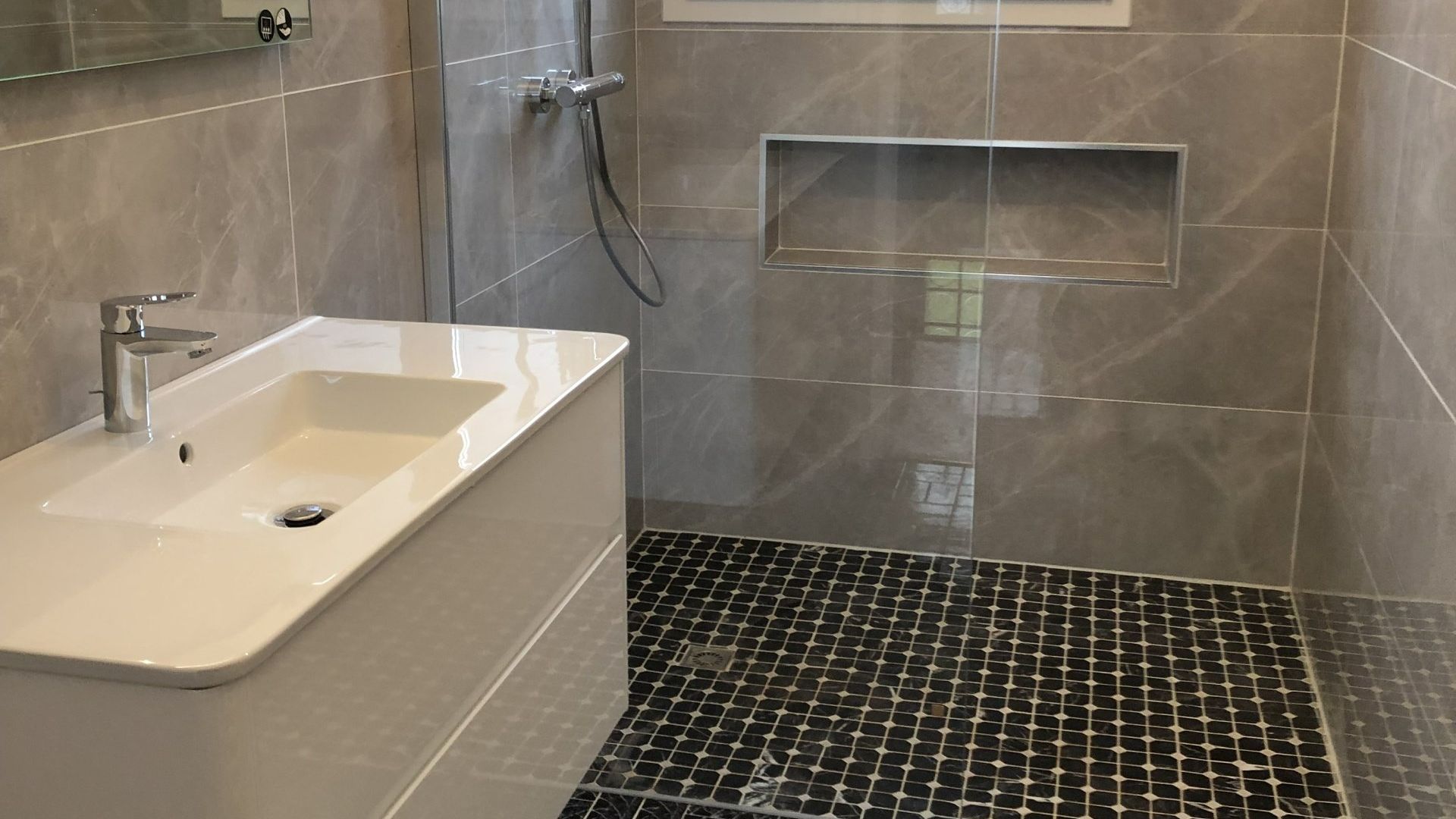 Salle de bains sur mesure avec douche et vasque.