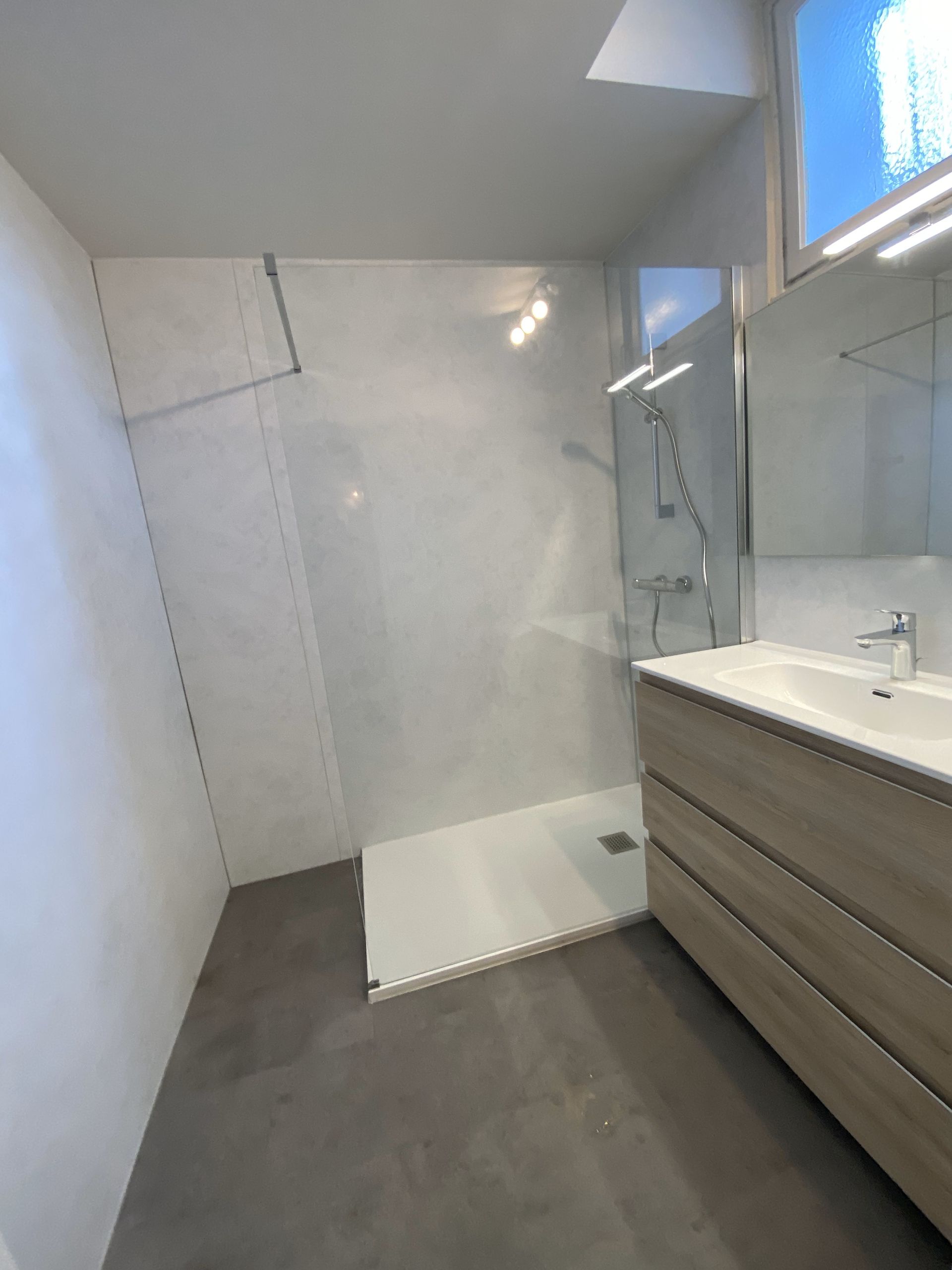 Salle de bains avec une douche et un meuble avec une vasque.