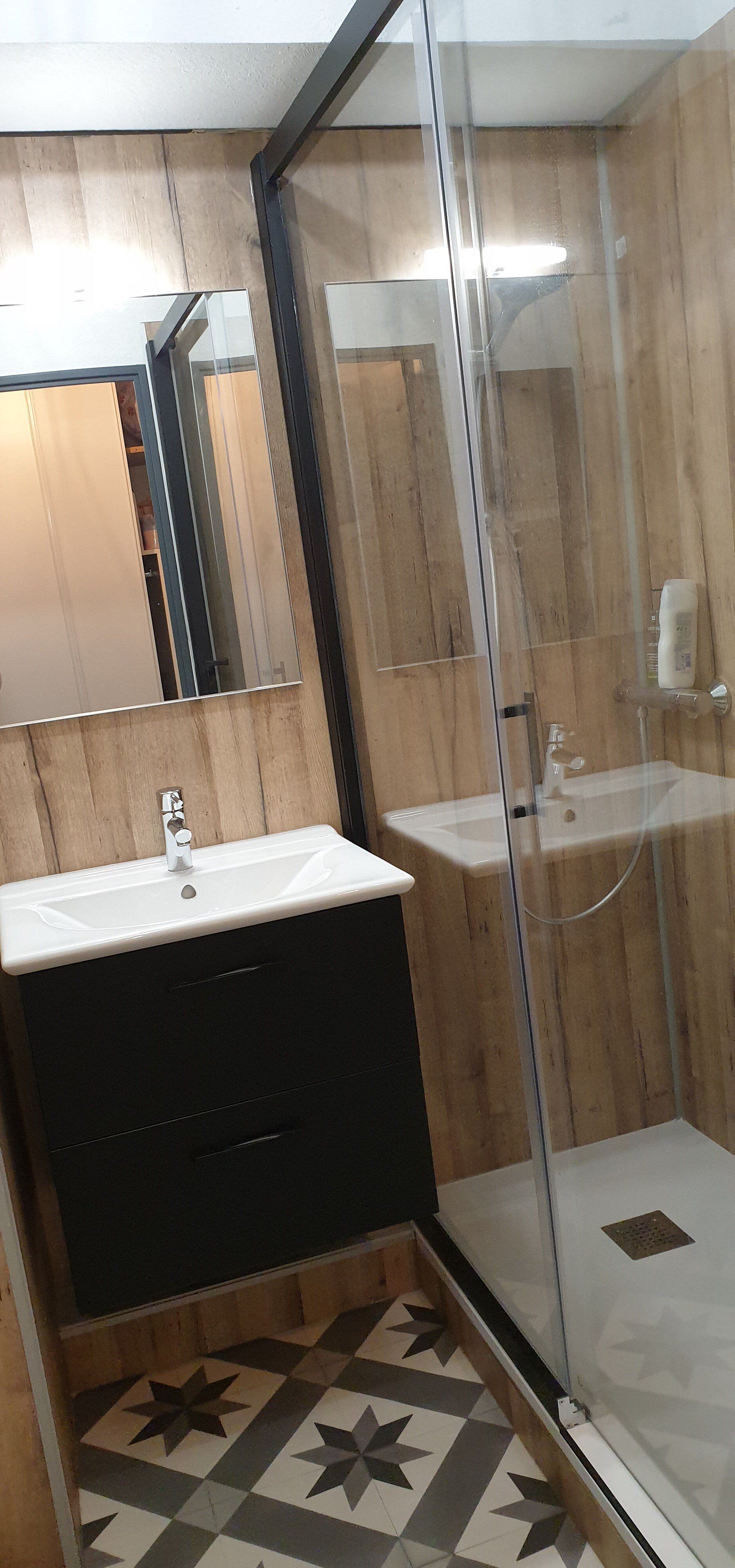 Salle de bains rénovée avec panneaux muraux.