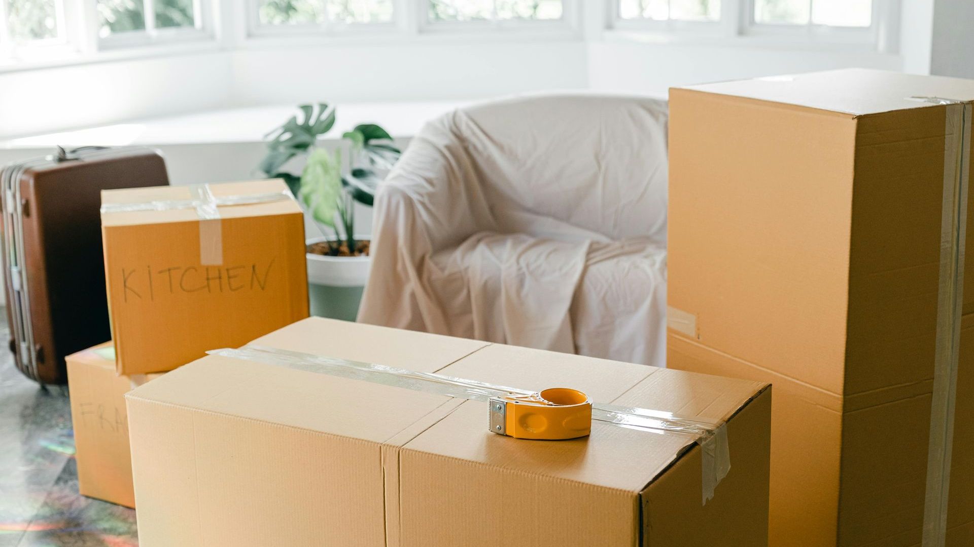 Ein Wohnzimmer voller Pappkartons und einer Couch.