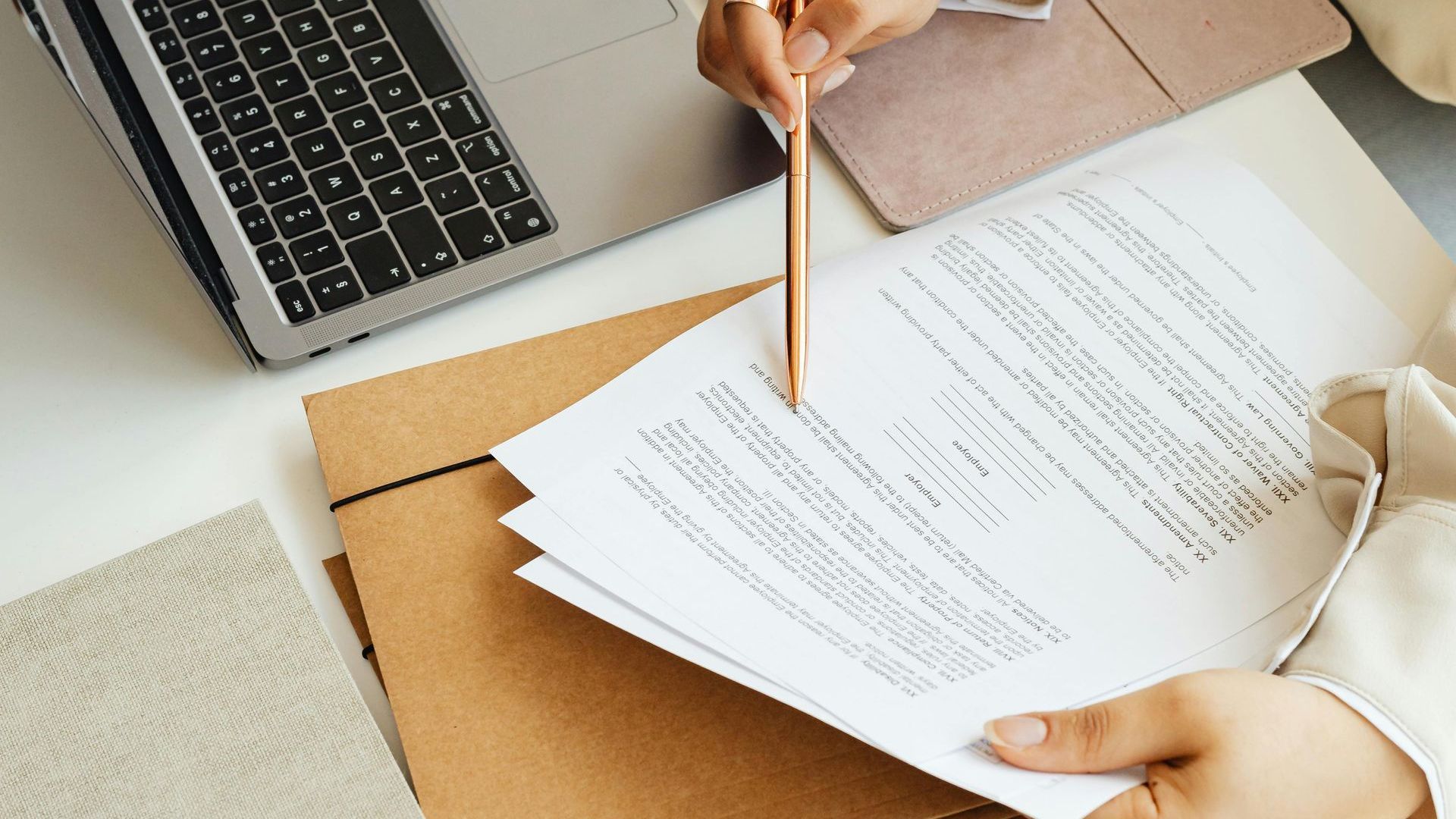 Eine Person schreibt mit einem Bleistift auf ein Blatt Papier.