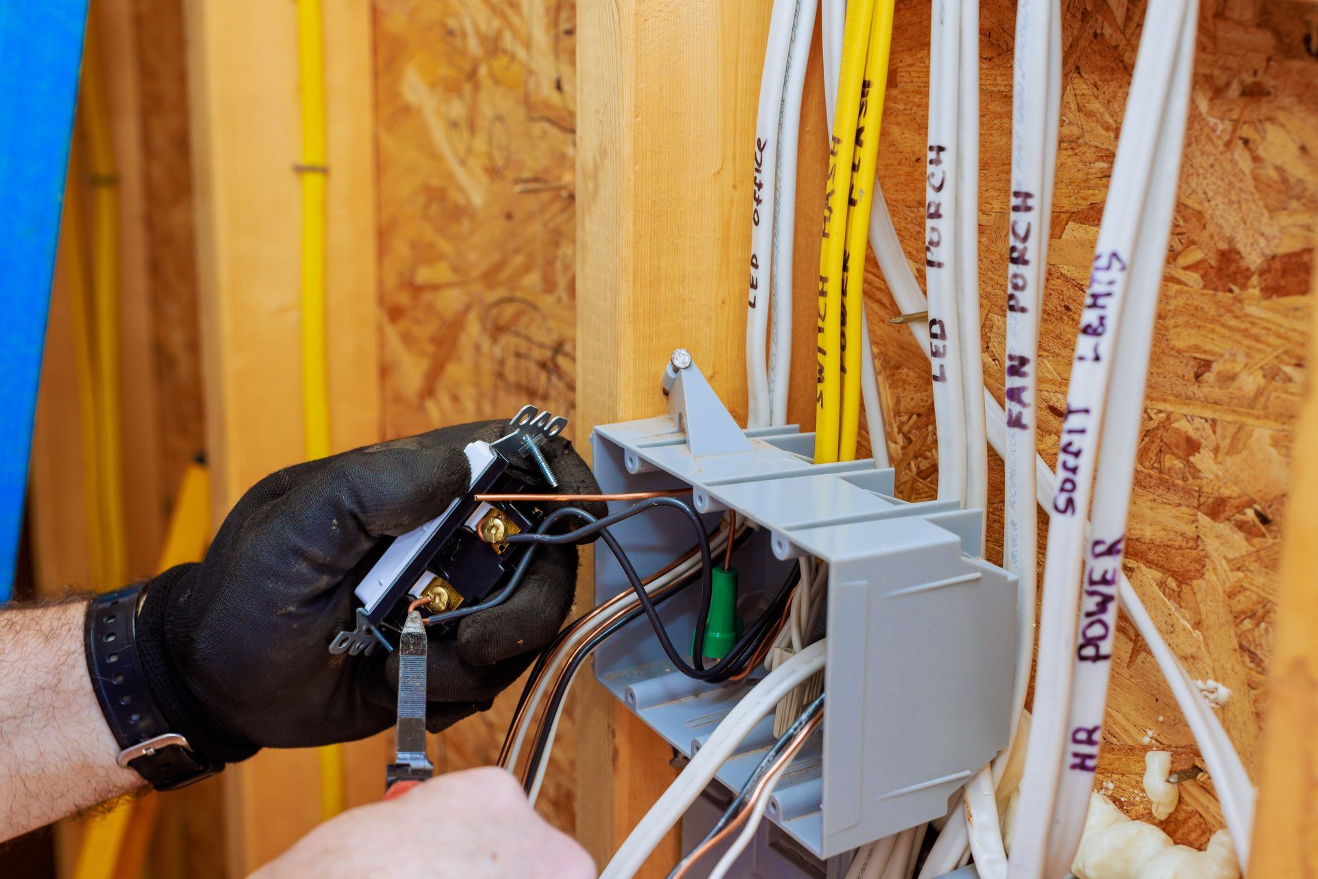Une personne qui installe des prises électriques dans une maison en construction.