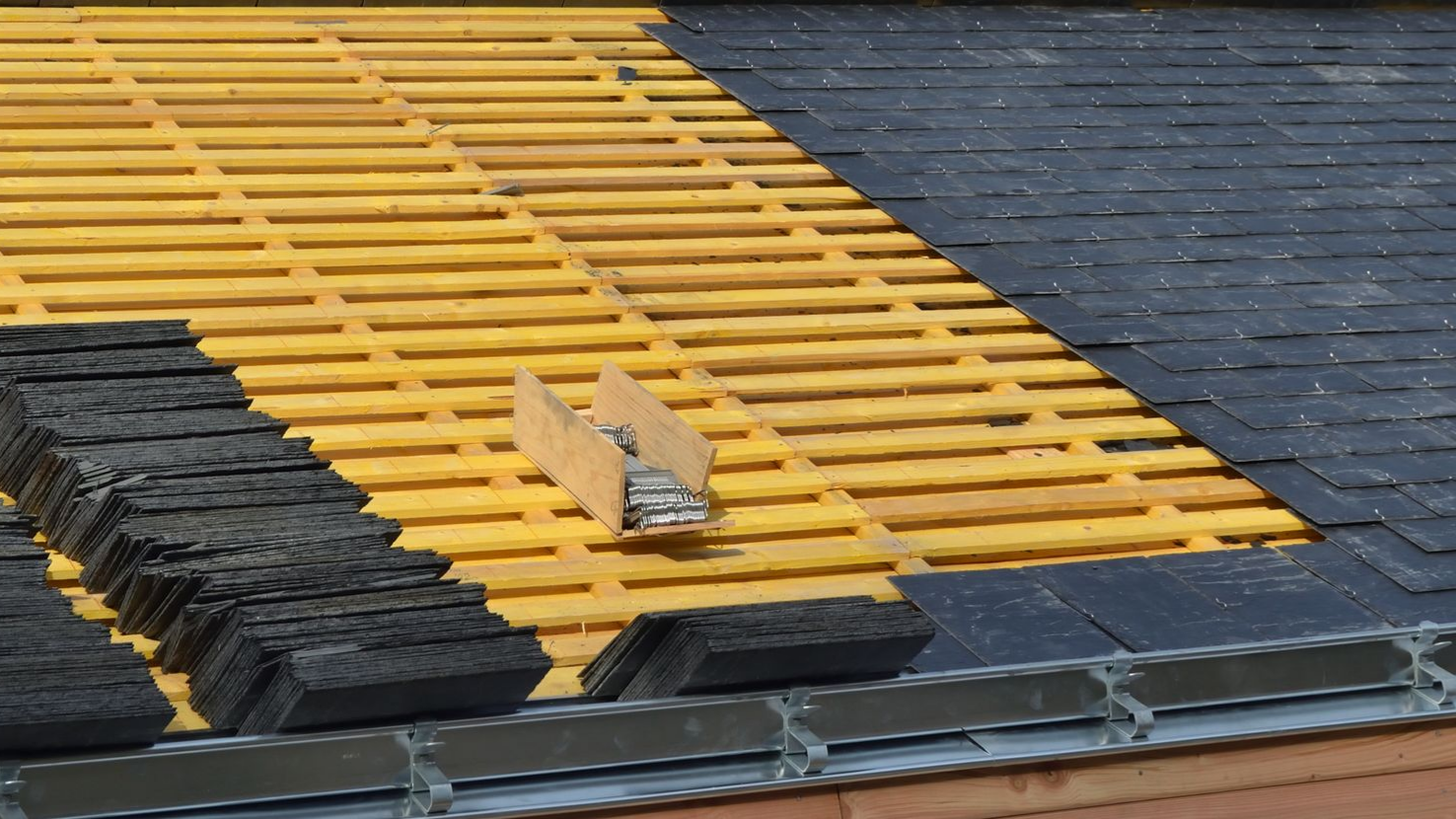 Pose de tuiles sur une charpente en bois