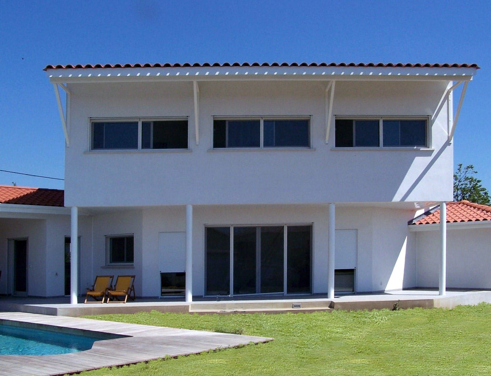 Maison blanche avec piscine et terrasse en bois