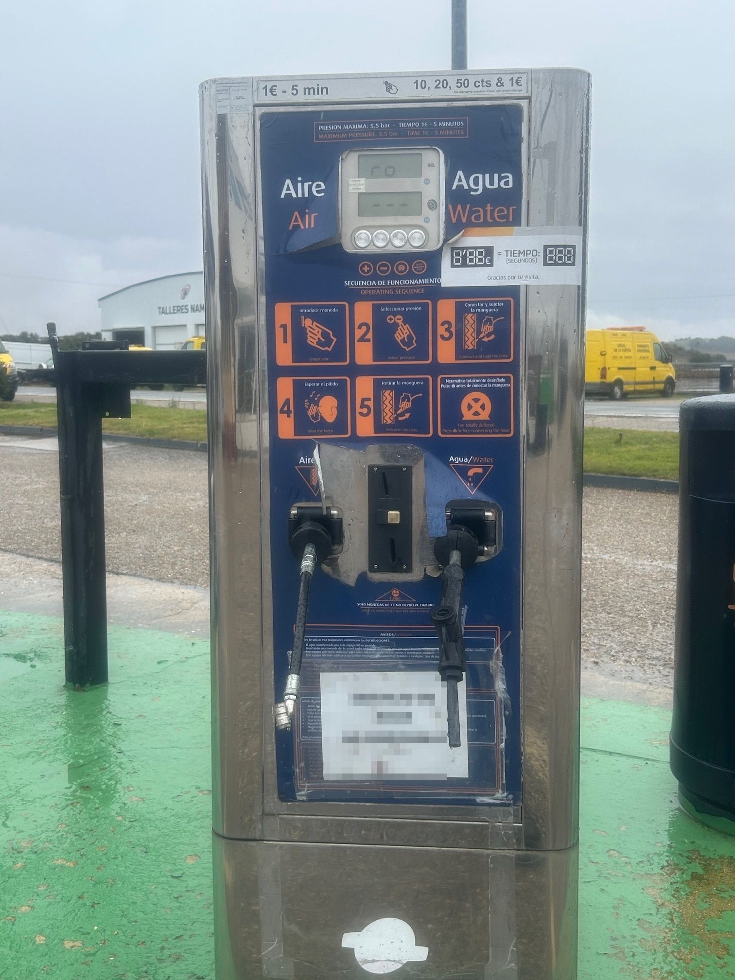 Inflador de neumáticos de metal con instrucciones, al aire libre sobre una superficie verde.