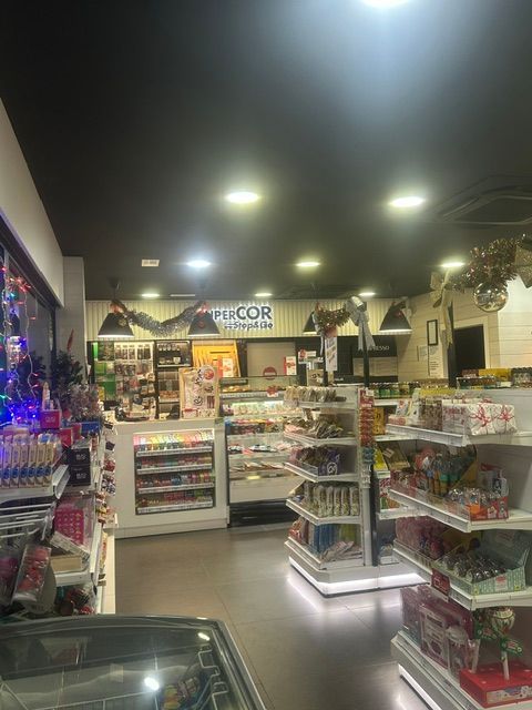 Gasolinera Repsol con cartel negro alto; edificio de apartamentos al fondo.