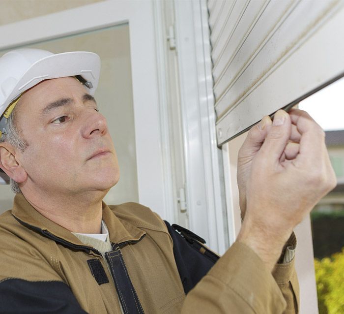 Un hombre que lleva un casco está trabajando en una ventana.