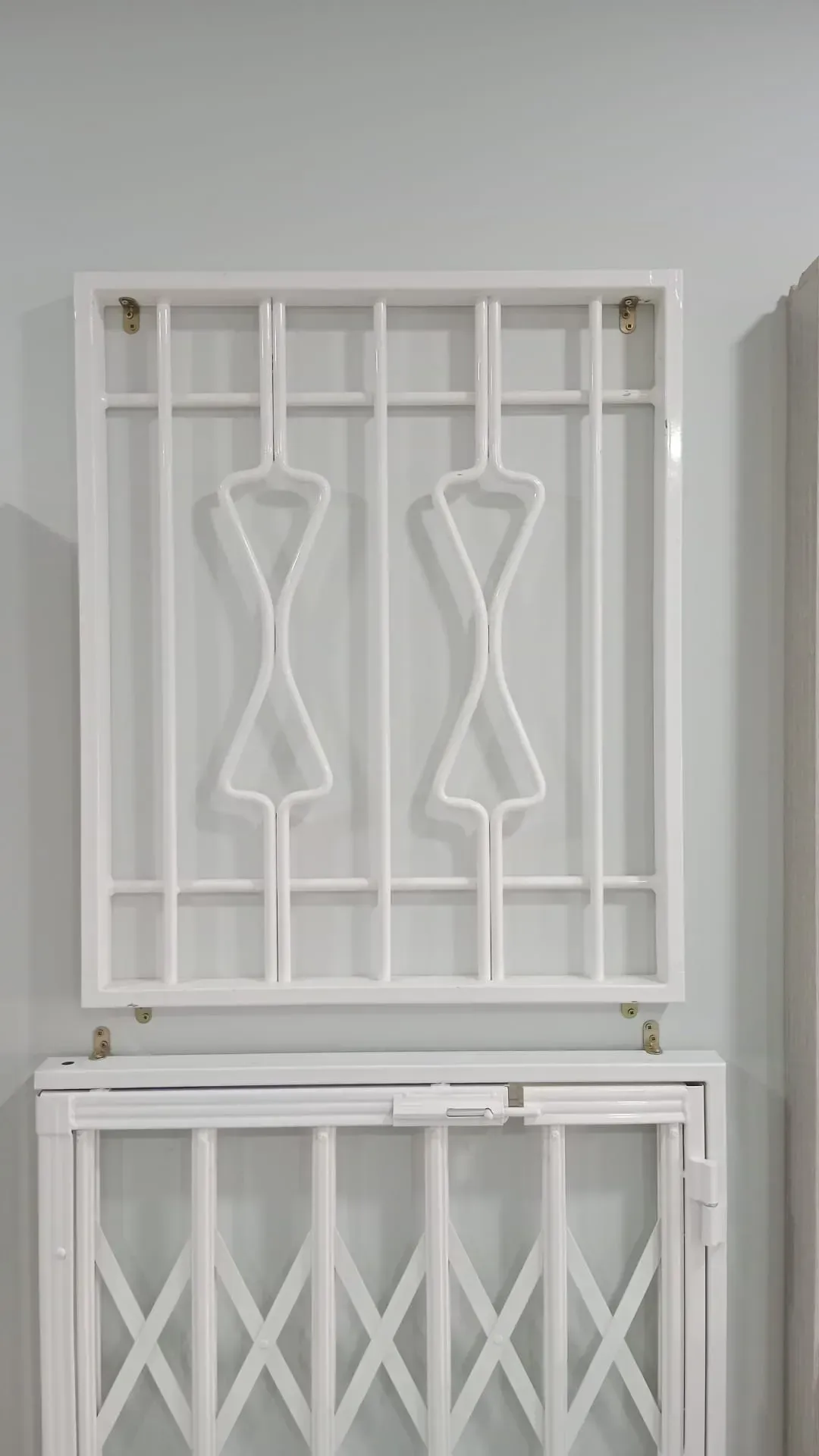 Una ventana blanca con una rejilla de metal encima.