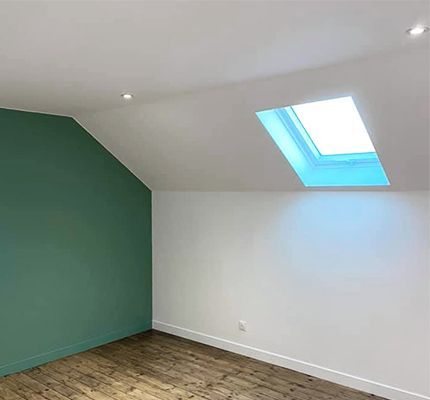 Intérieur avec murs verts et blancs, puits de lumière et parquet.