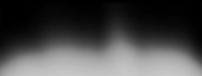 Image floue en noir et blanc avec des traînées lumineuses partant du bas.