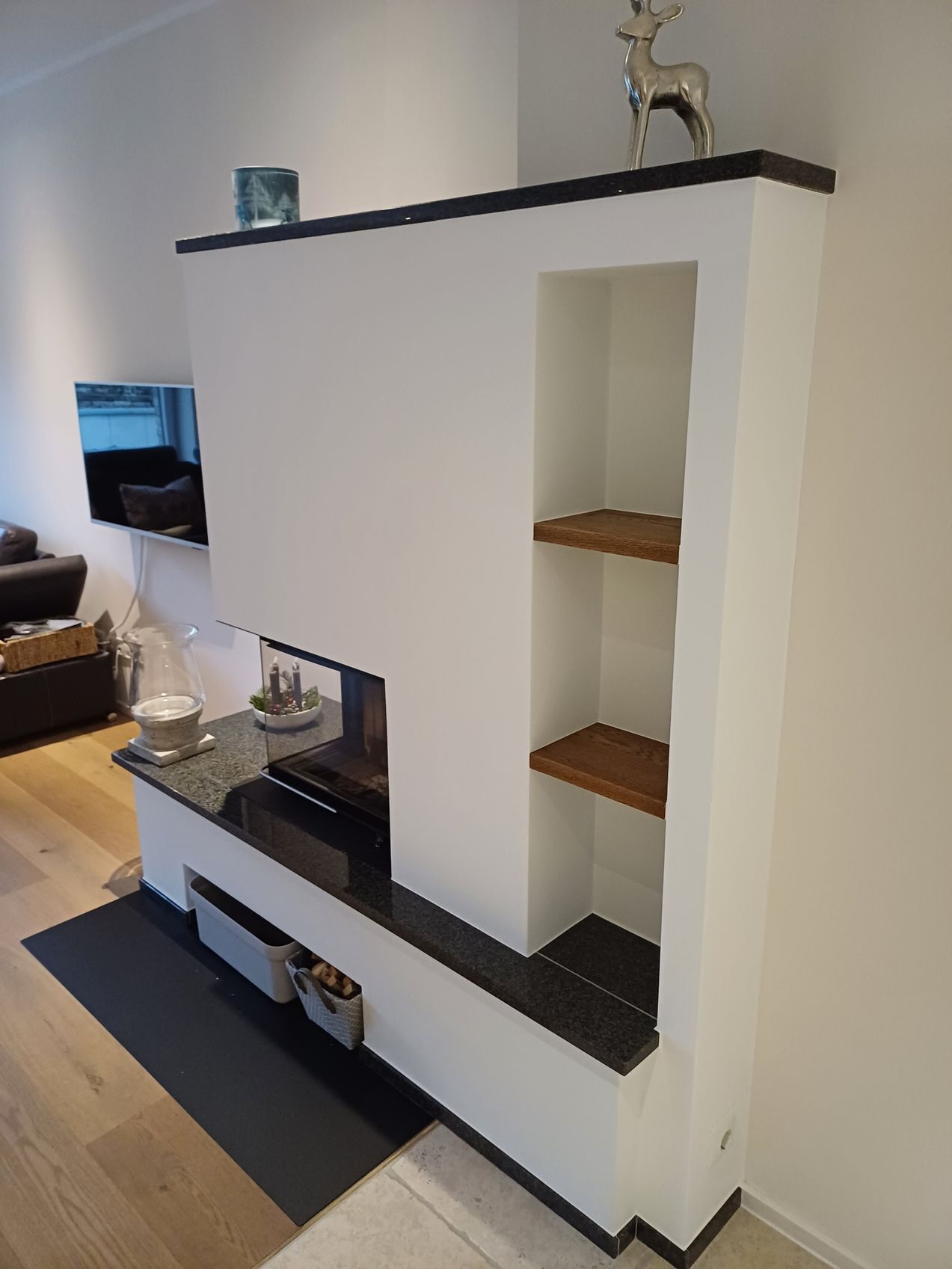 Ein Wohnzimmer mit Kamin und einem Regal mit einem Hirsch darauf.