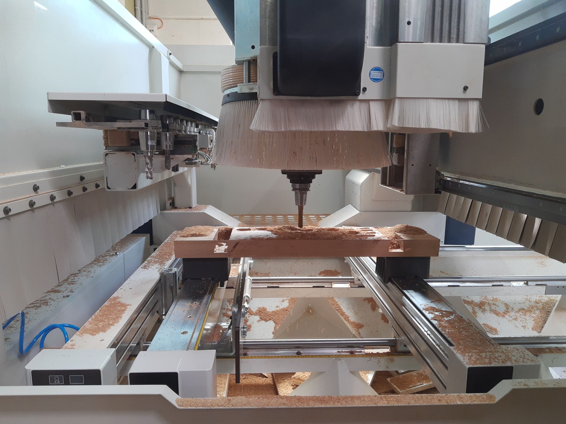 Eine Maschine schneidet ein Stück Holz auf einem Tisch.