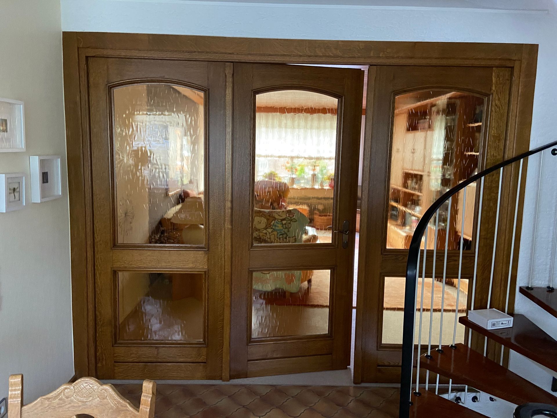 Ein Wohnzimmer mit Wendeltreppe und Holztüren.