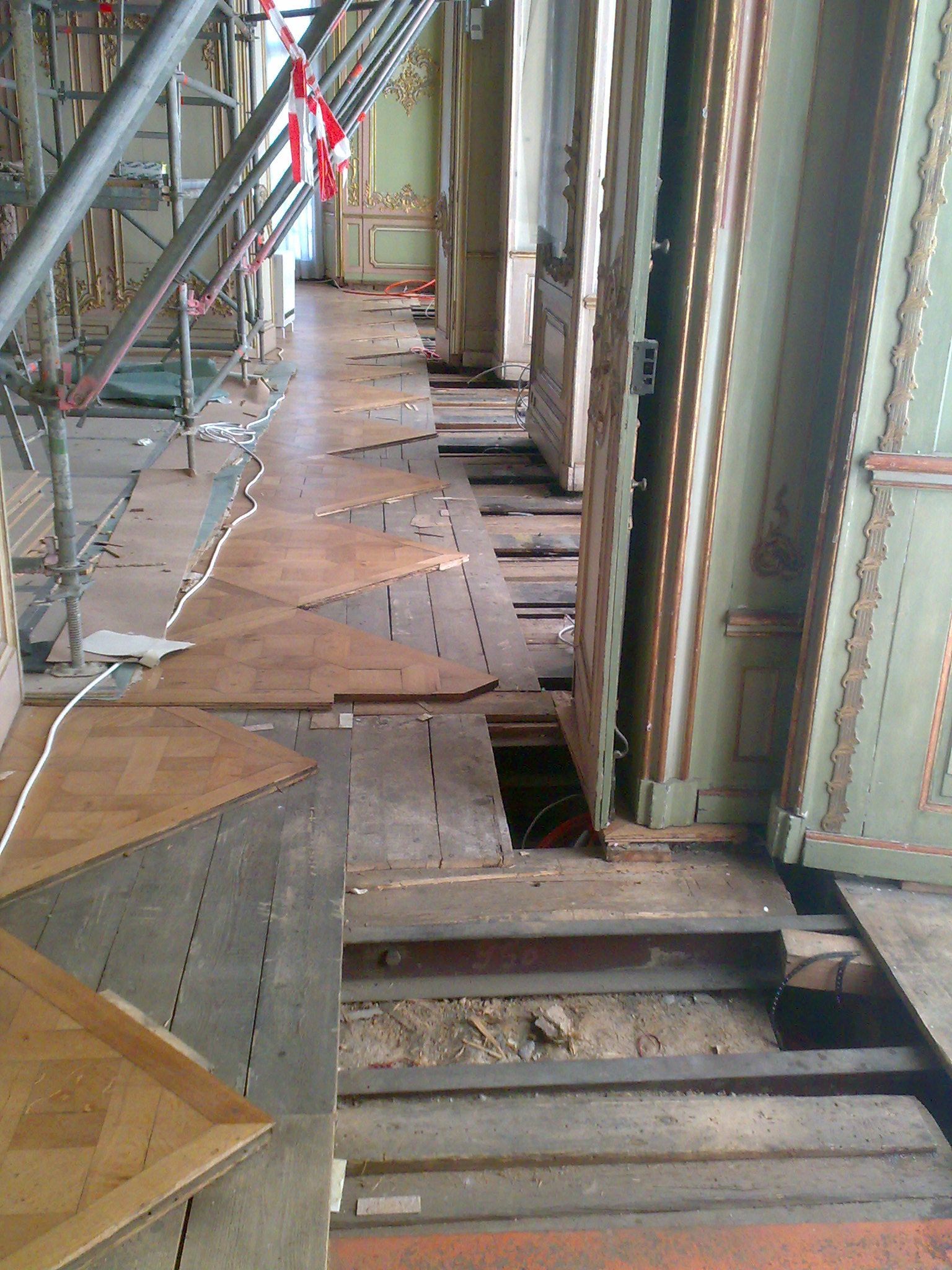Ein Flur mit Holzböden und Gerüst im Hintergrund