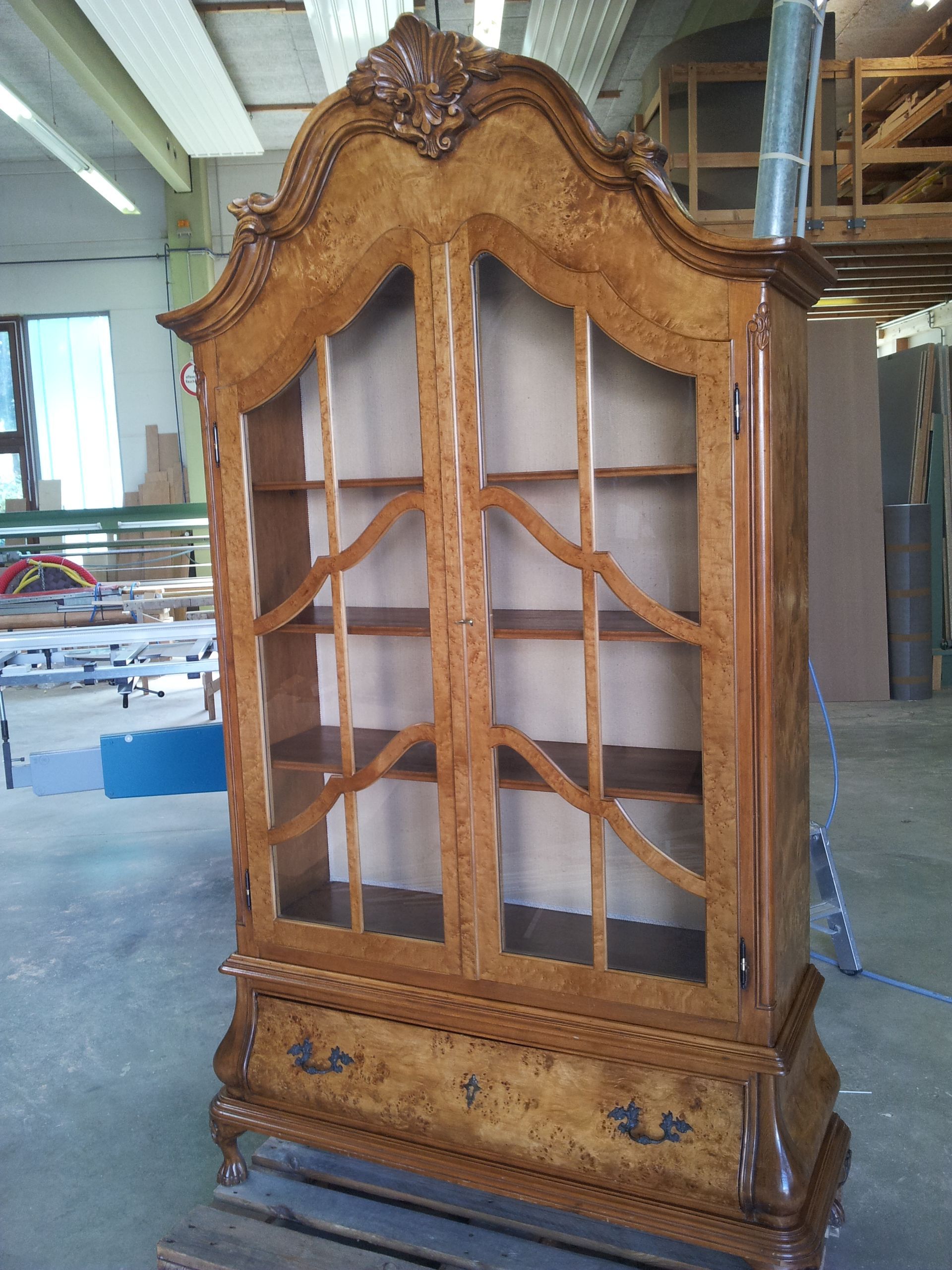 Ein großer Holzschrank mit Glastüren und Schubladen