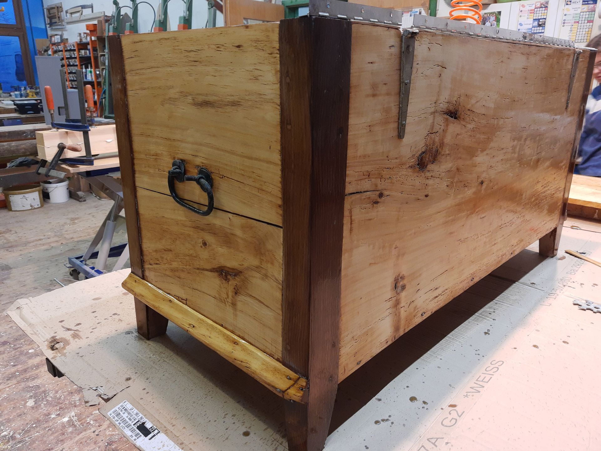 Auf einem Tisch steht eine Holzkiste mit Griff