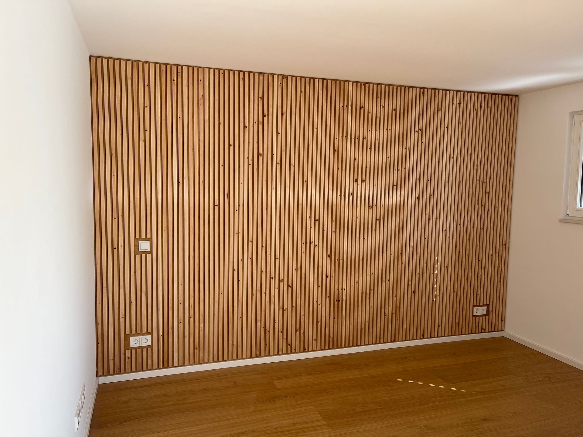 Ein leerer Raum mit einer Holzwand und einem Holzboden.