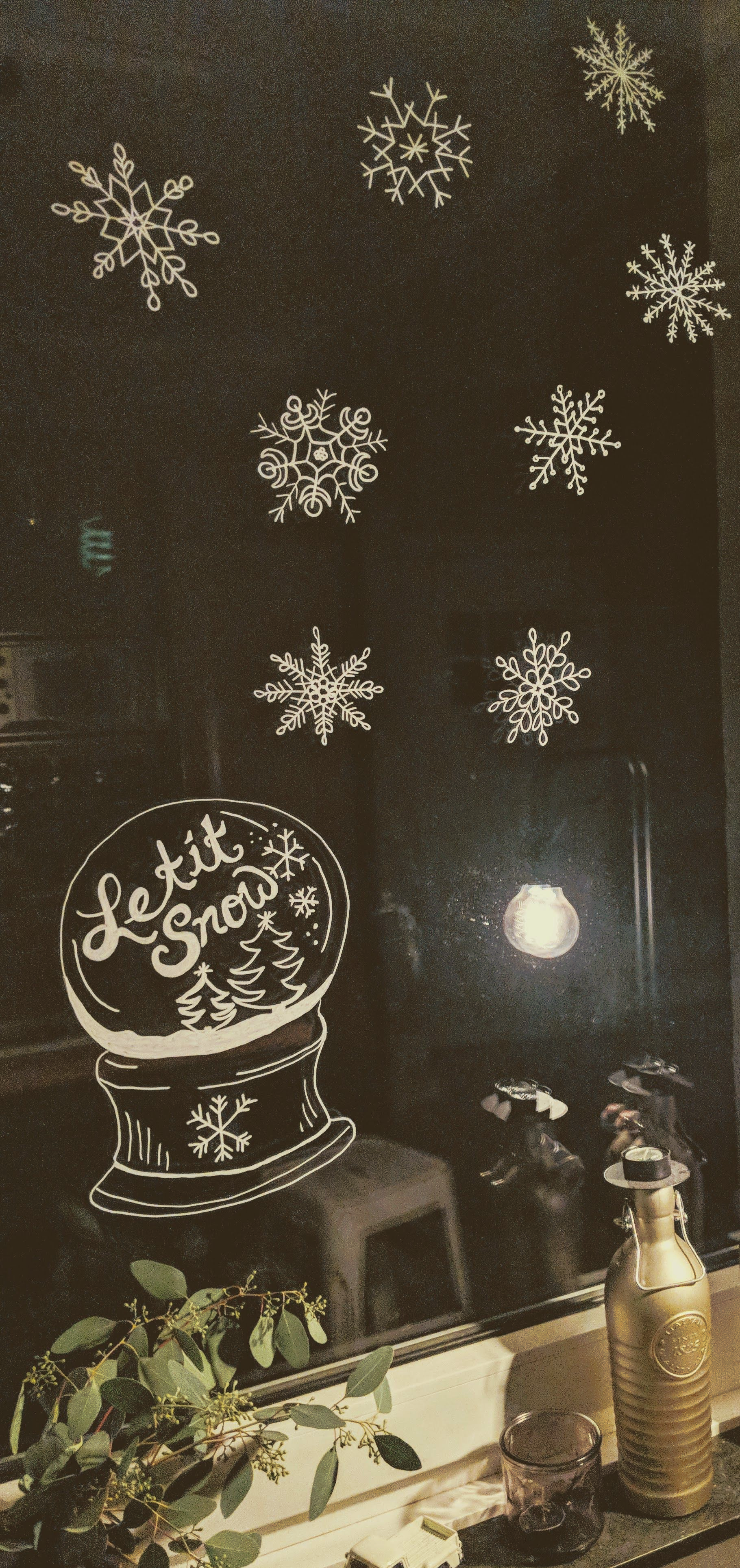 Fenstermalerei Schneekugel und Schneeflocken.