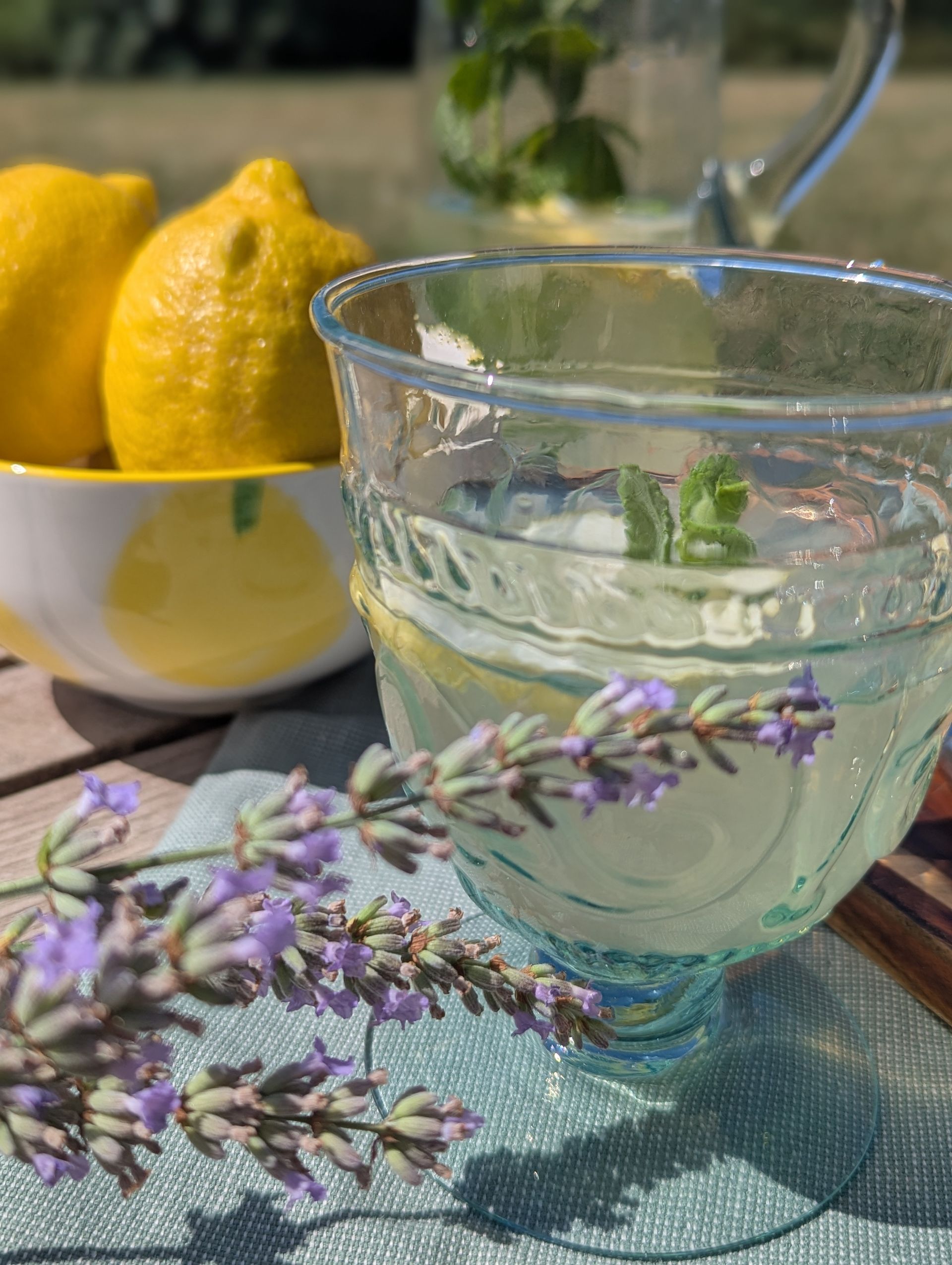 Lavendellimonade im Glas mit Lavendelblüten und Zitronen auf dem Tisch