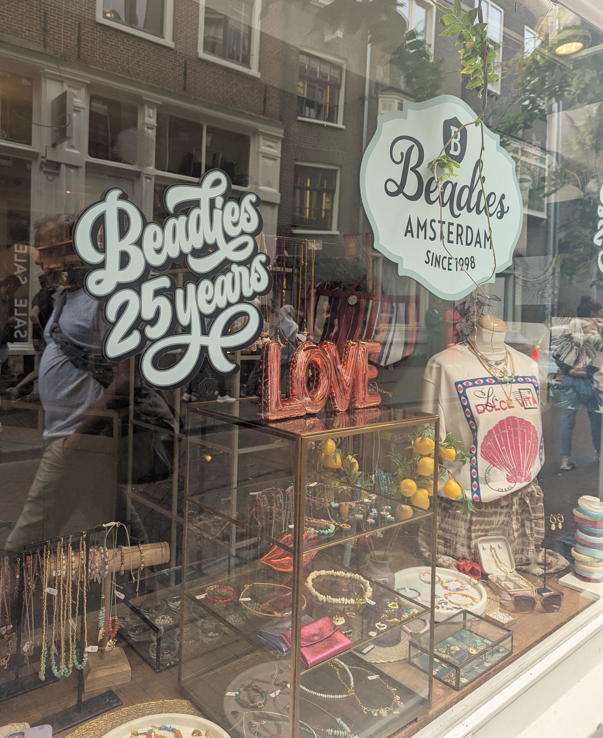 Schaufenster eines Beadies-Schmuckgeschäfts in Amsterdam mit Schildern, Displays und dem Wort „LOVE“.
