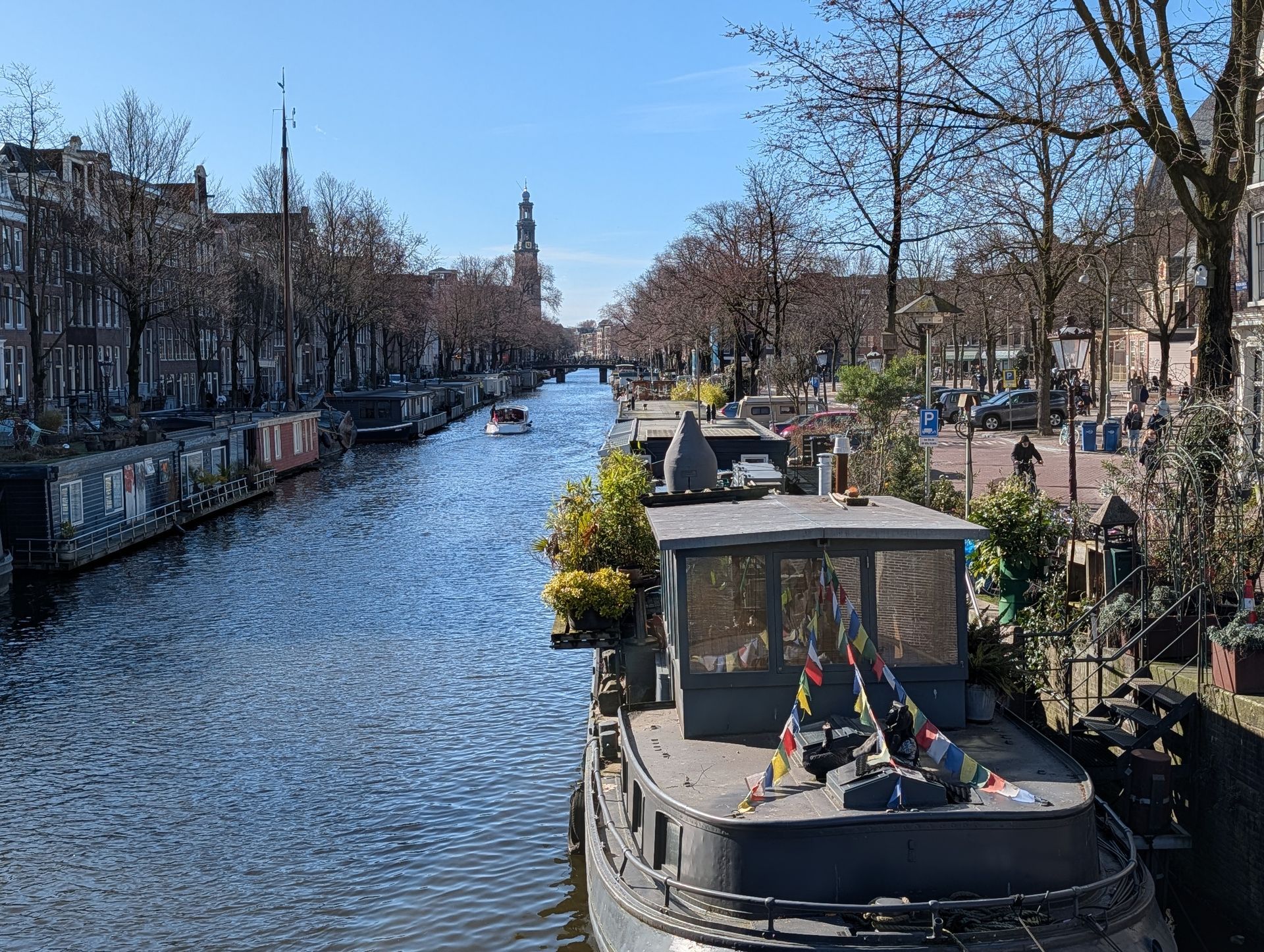 Eine Gracht in Amsterdam mit Hausbooten an den Seiten.