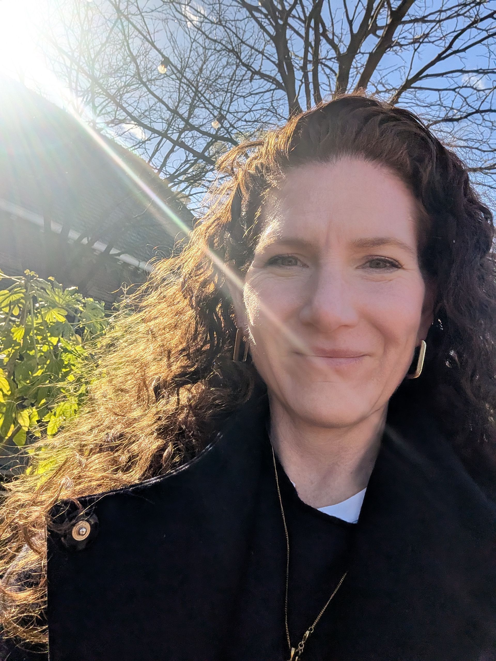 EIn Portraitbild mit Sonne im Hintergrund.