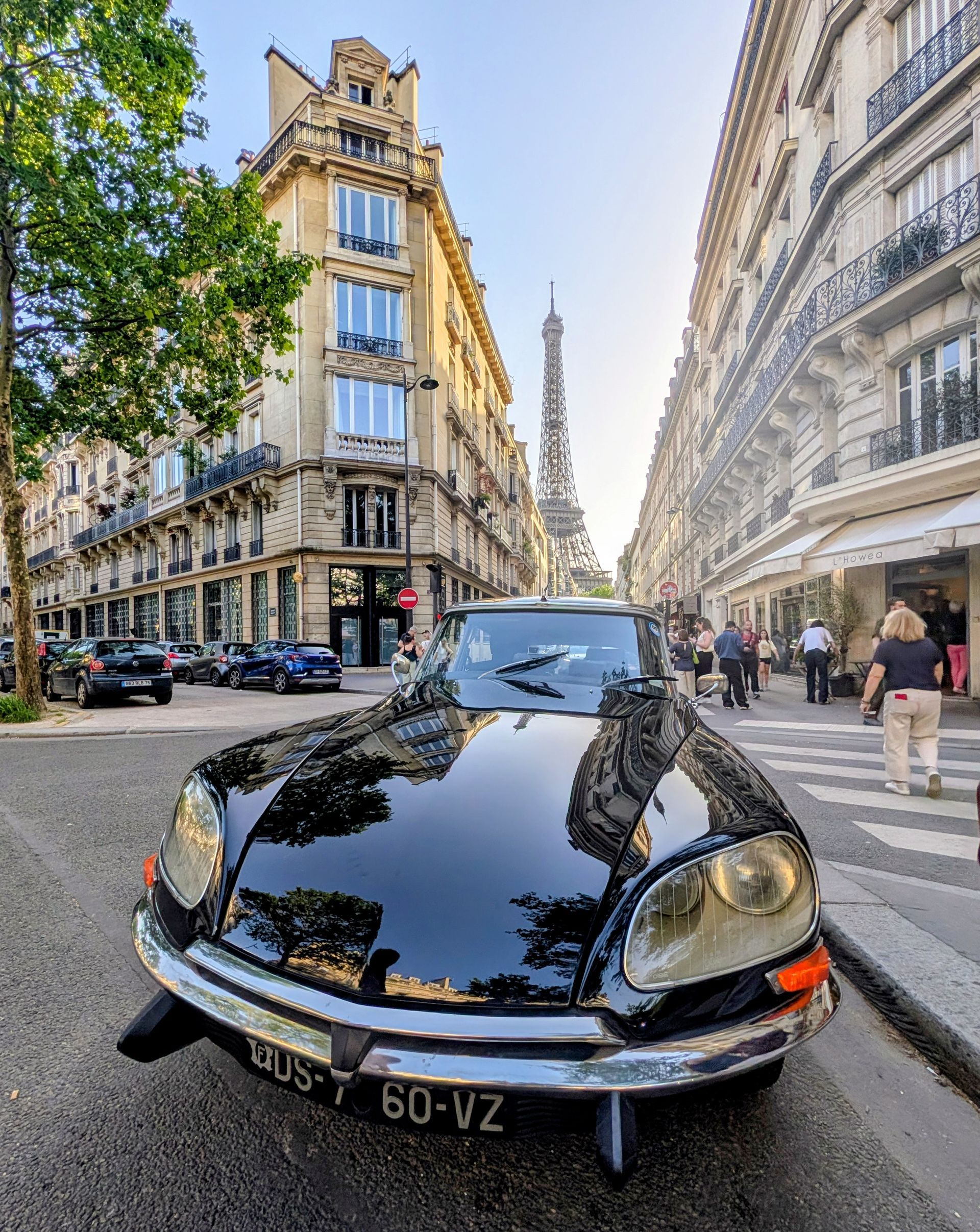 Ein schwarzer Citroën DS21 vor dem Eiffelturm.