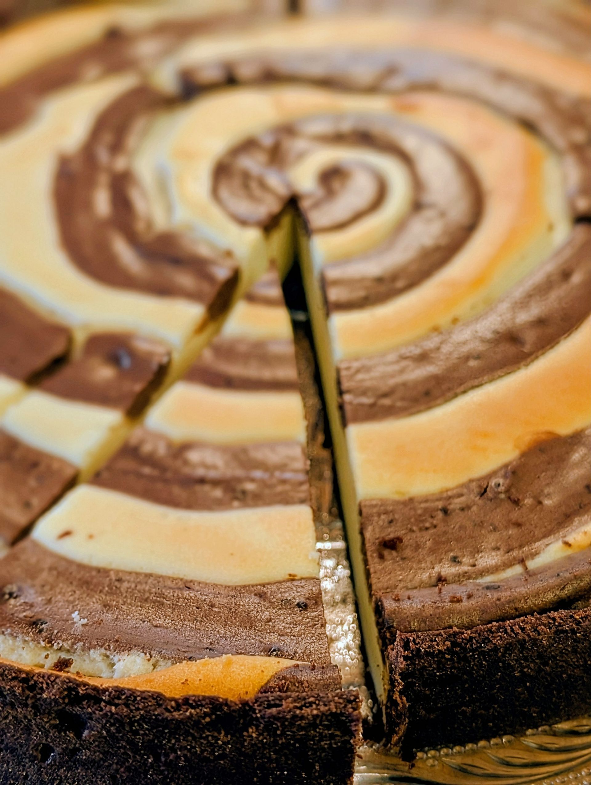 Pumpkin-Spice-Cheesecake. Ein Stück ist angeschnitten.