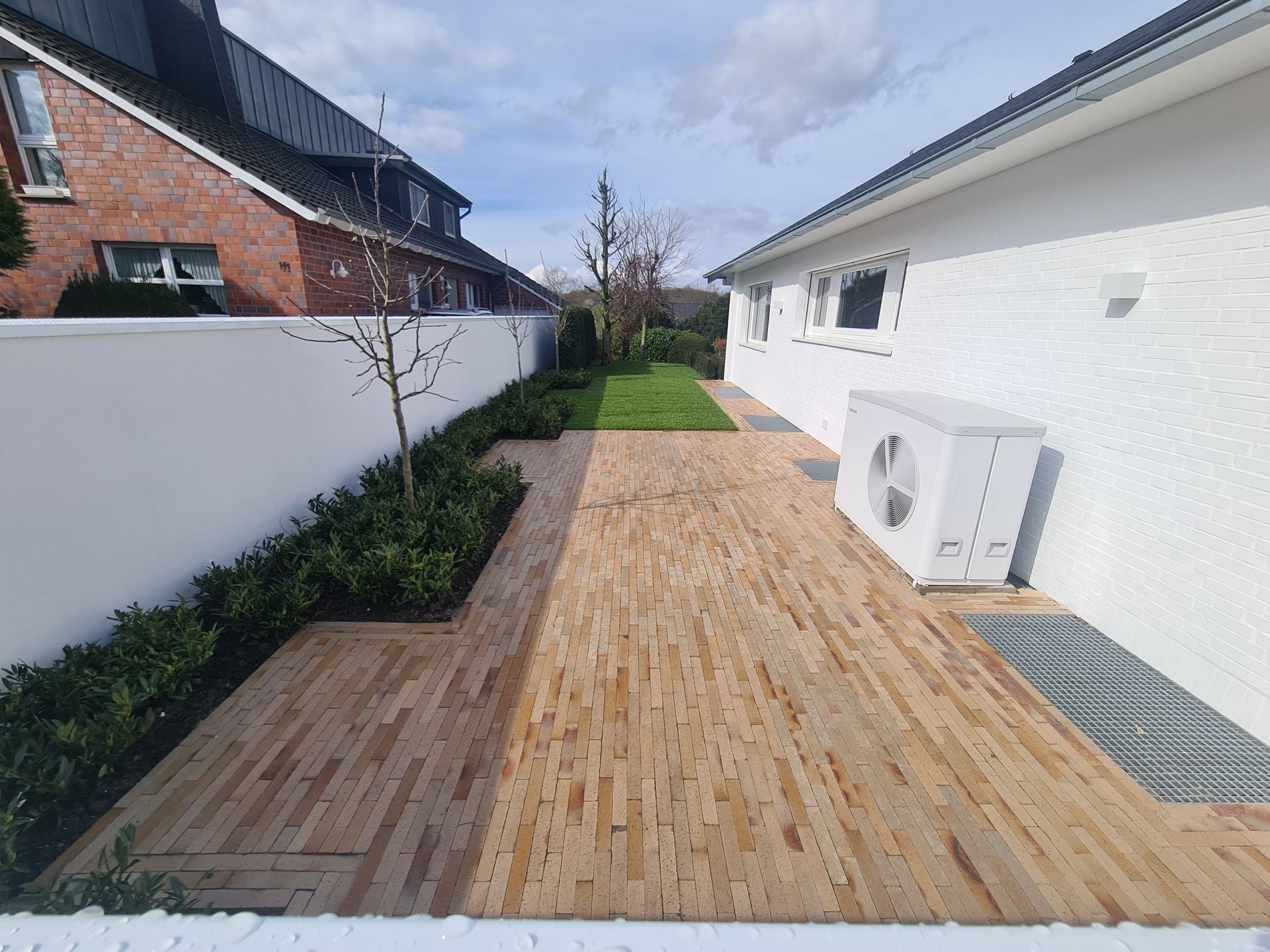 Ein weißes Haus mit einem gepflasterten Weg