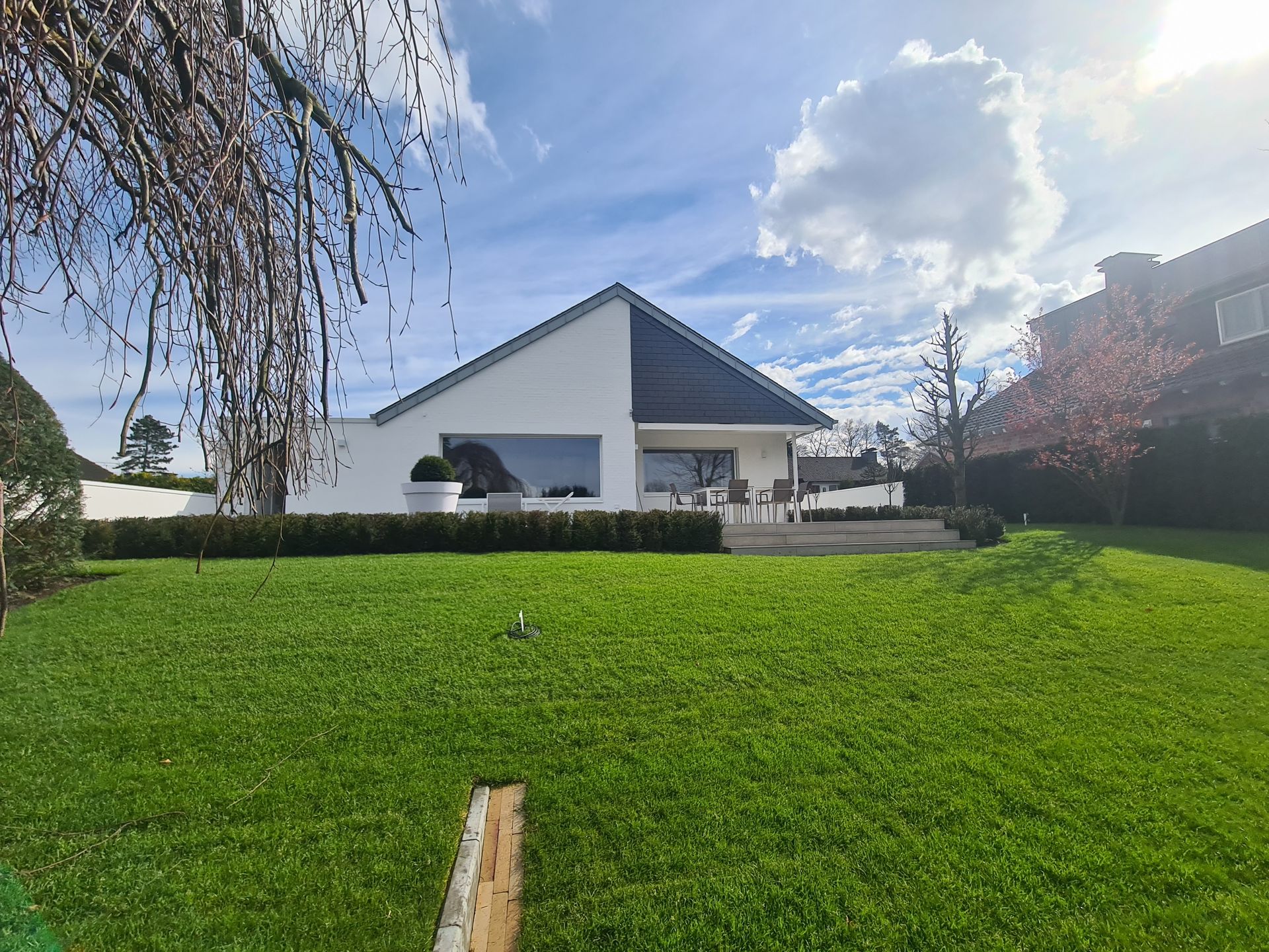 Ein weißes Haus mit einer großen Wiese davor