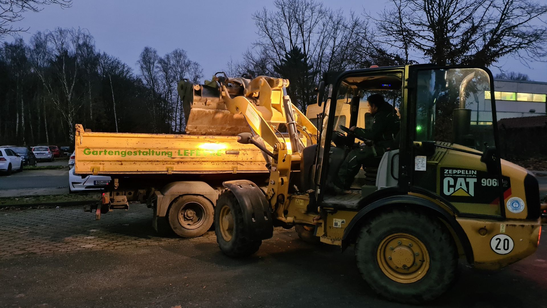 Ein Yellow Cat-Muldenkipper steht nachts auf einem Parkplatz