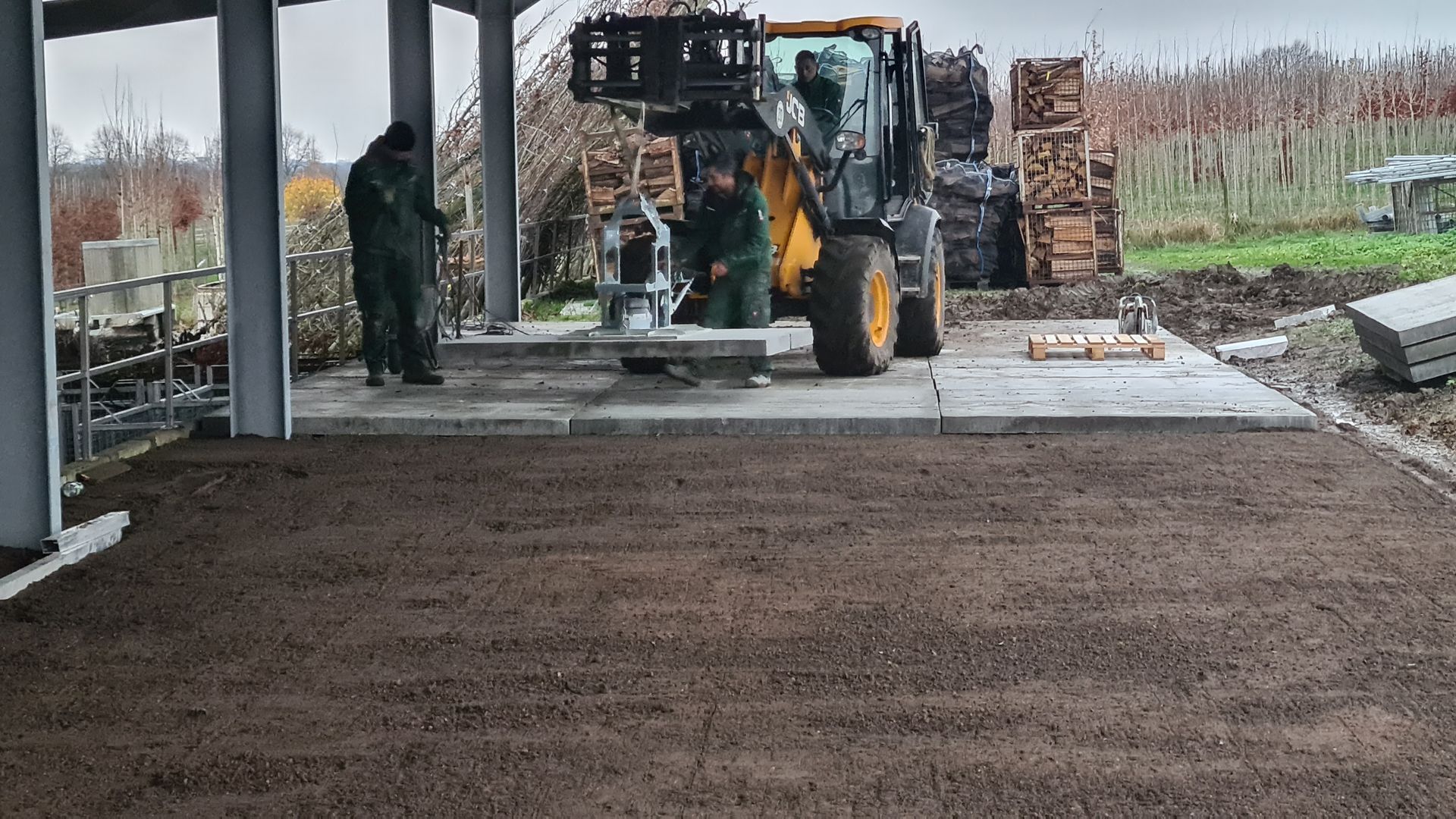 Ein Mann steht neben einem Traktor auf einer Baustelle