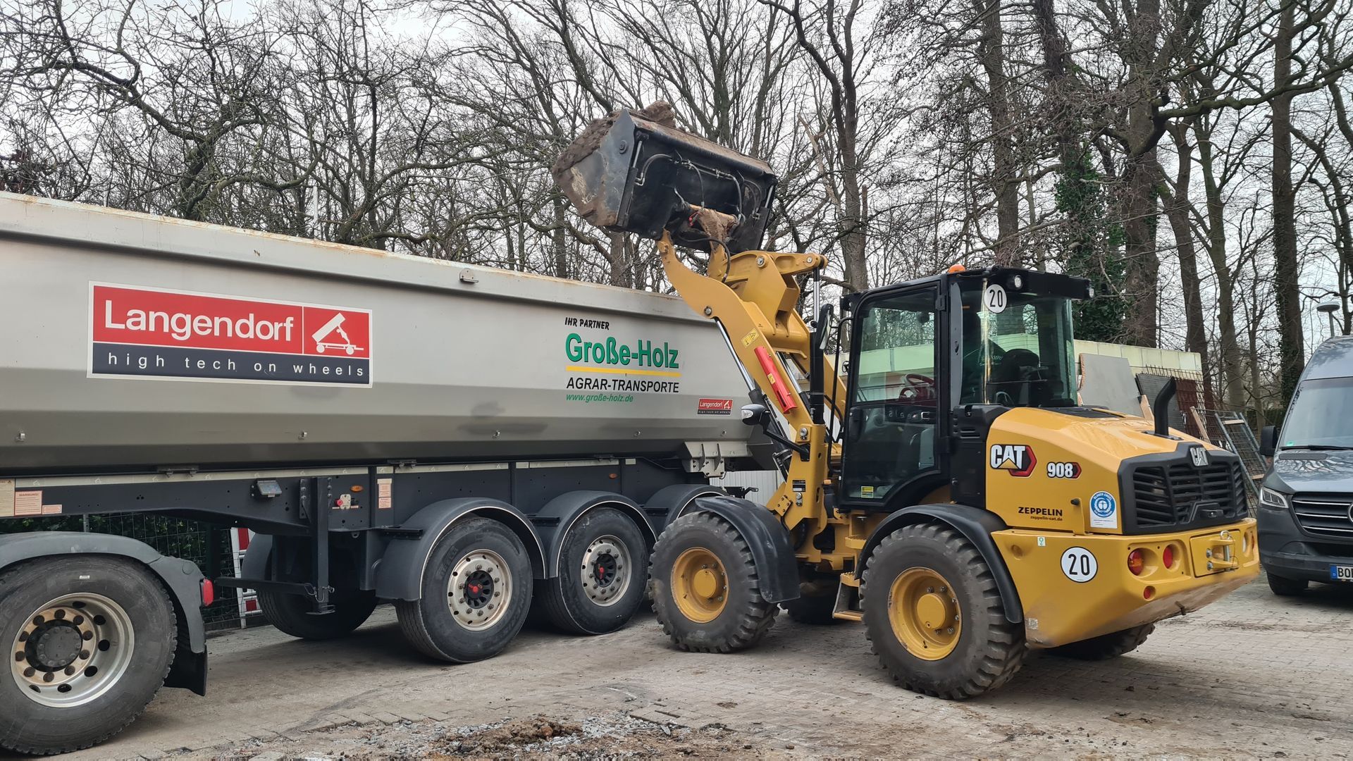 Eine Planierraupe lädt Erde in einen Muldenkipper